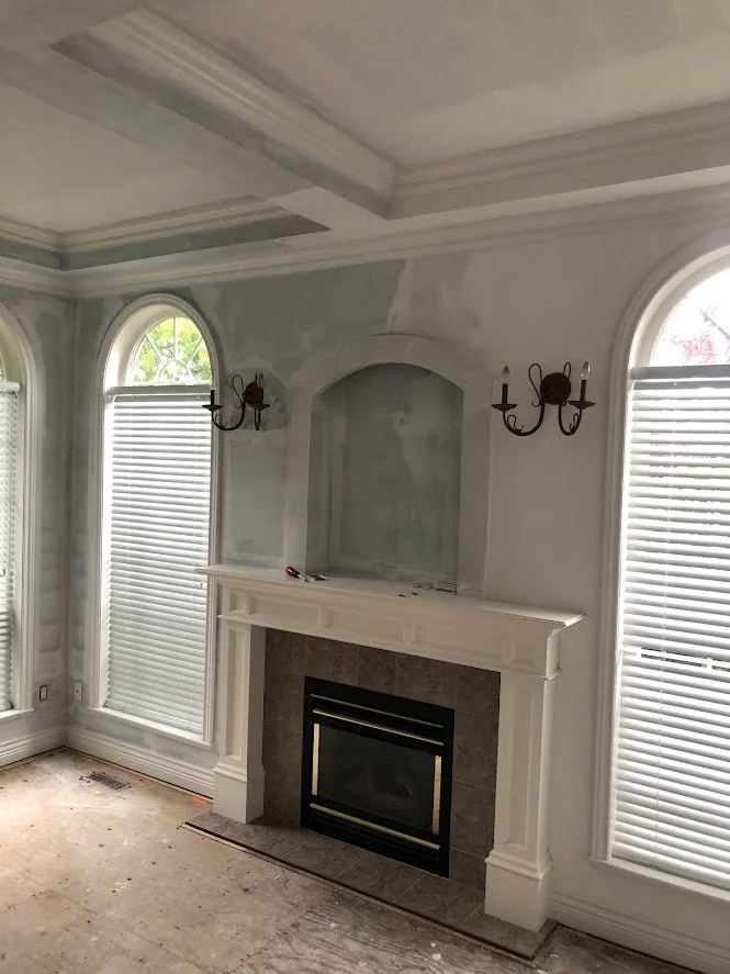 Before ... the client had just had this room renovated, and they had primed most of the walls (except behind that cabinet where you can see the unprimed area). They wanted the crown molding, the ceilings and the walls painted!