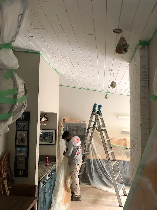 After spraying the ceilings with oil primer to block bleed through, we are removing the masking so we can paint the walls!