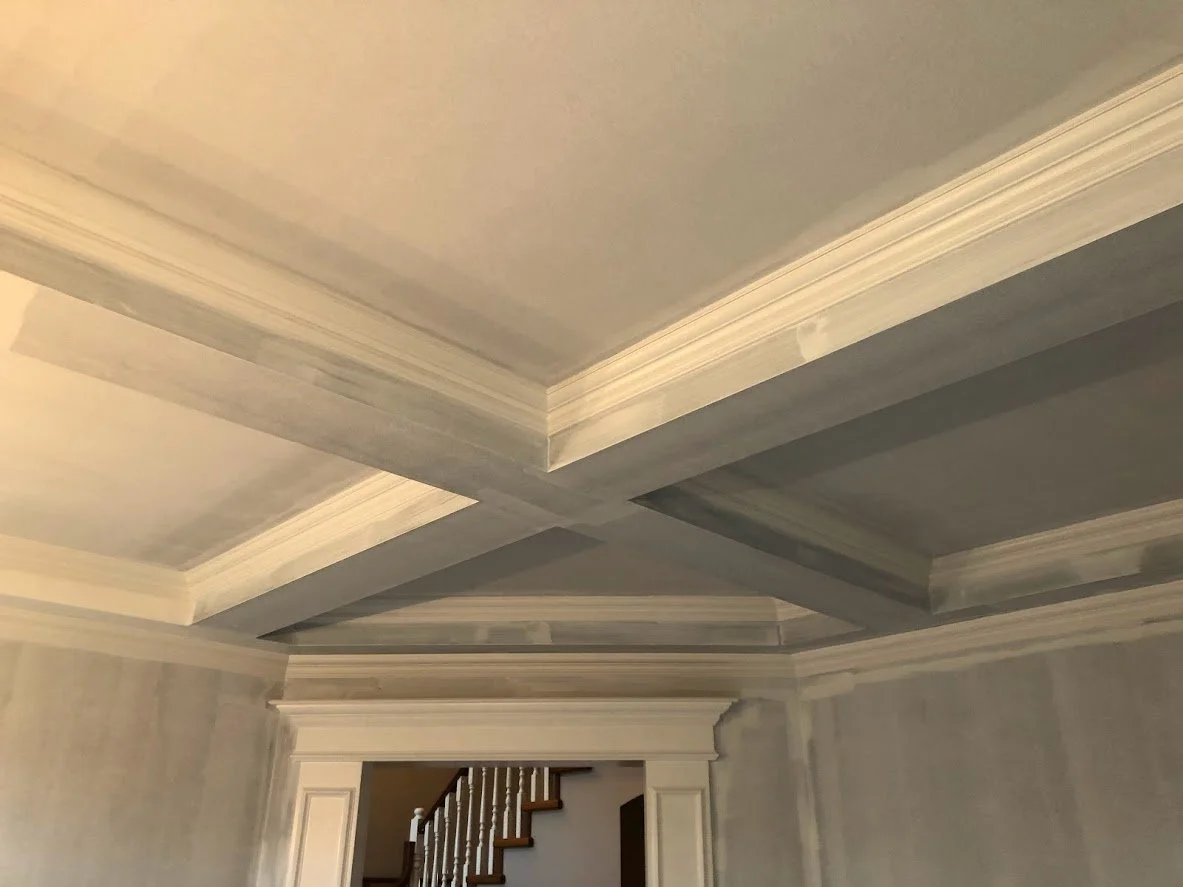 Before ... the client had just had this room renovated, and they had primed most of the walls (except behind that cabinet where you can see the unprimed area). They wanted the crown molding, the ceilings and the walls painted!