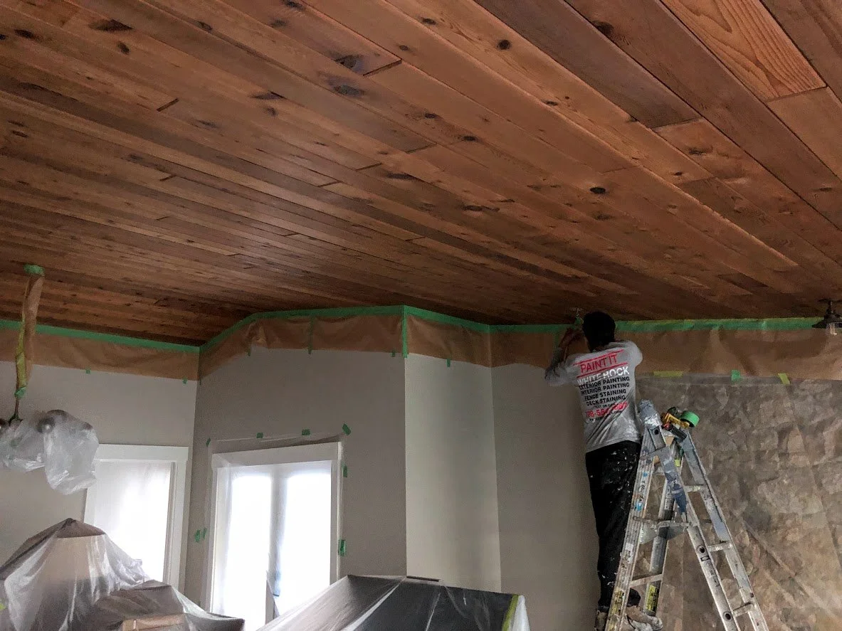 Before ... this beautiful wood ceiling had several stain marks, and it was too dark for the client, so we are masking the ceiling off before we sprayed it a fresh, bright white!