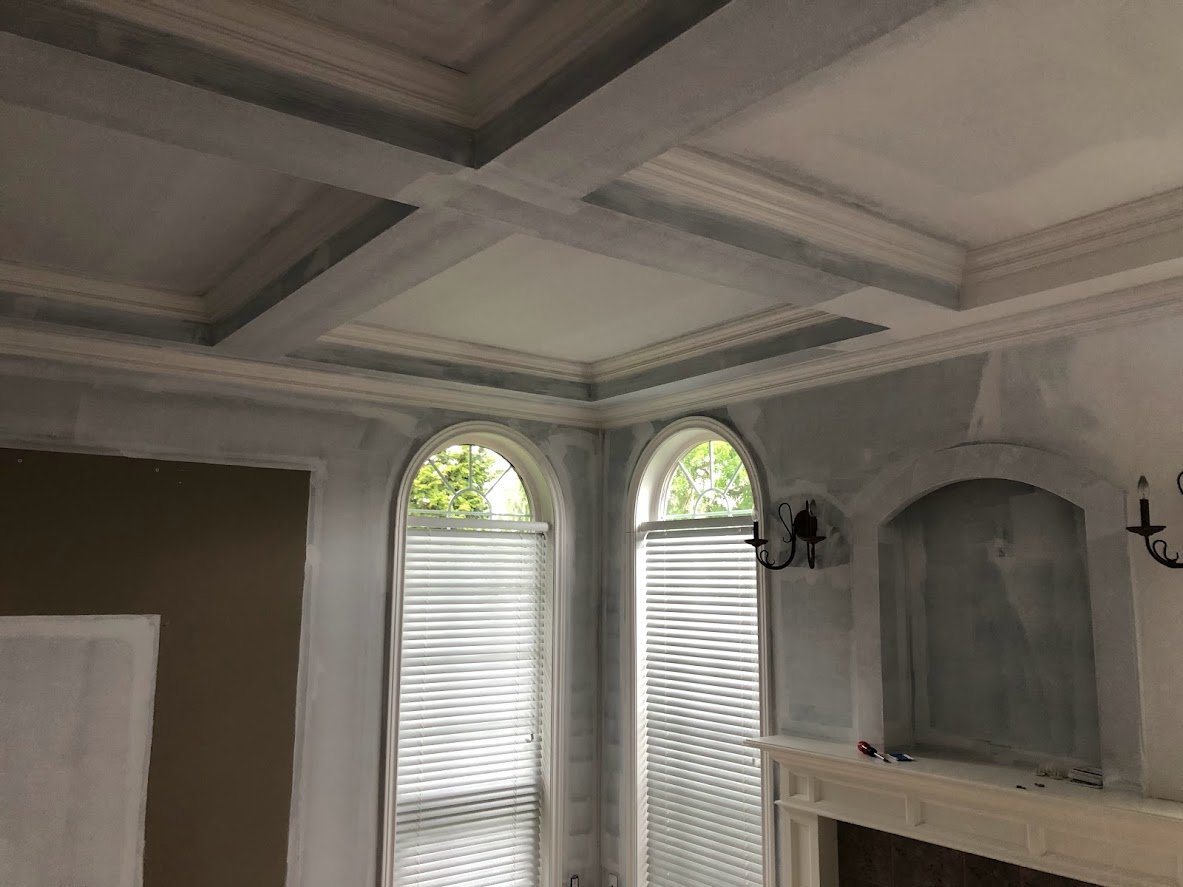 Before ... the client had just had this room renovated, and they had primed most of the walls (except behind that cabinet where you can see the unprimed area). They wanted the crown molding, the ceilings and the walls painted!