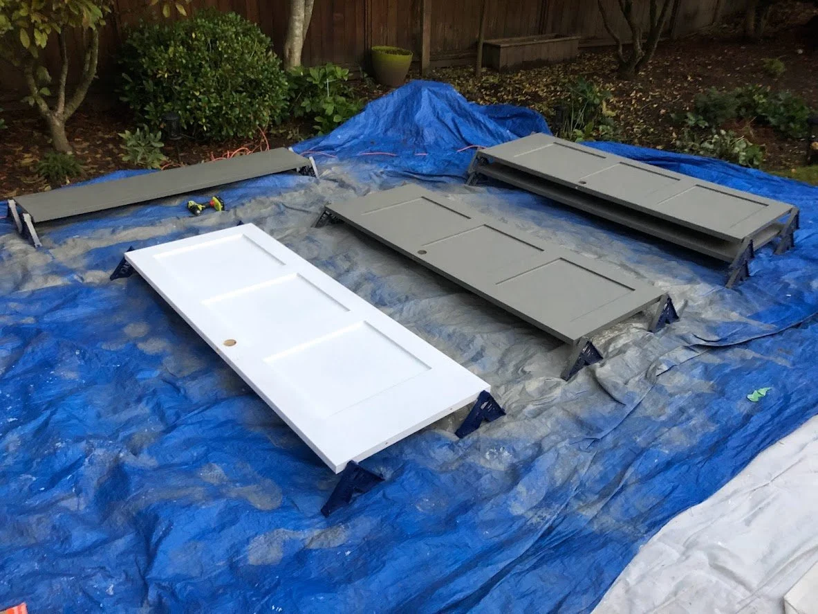 The white door on the left is just primed, and we had just sprayed the first coat on the doors on the right side!