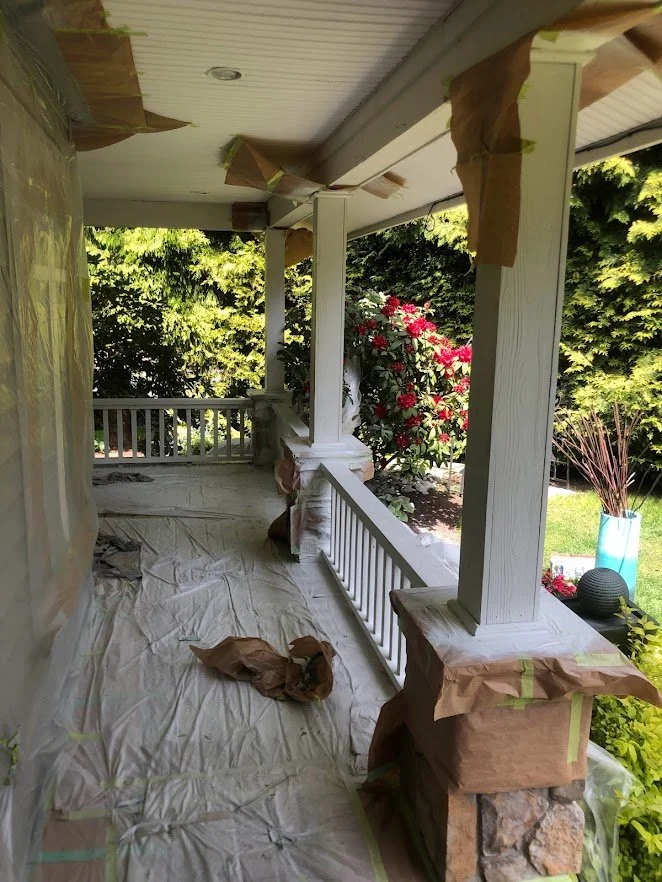 After spraying the siding, the posts and the railings / spindles. Next up: removing masking, painting the front door and staining (solid hide stain) the deck!