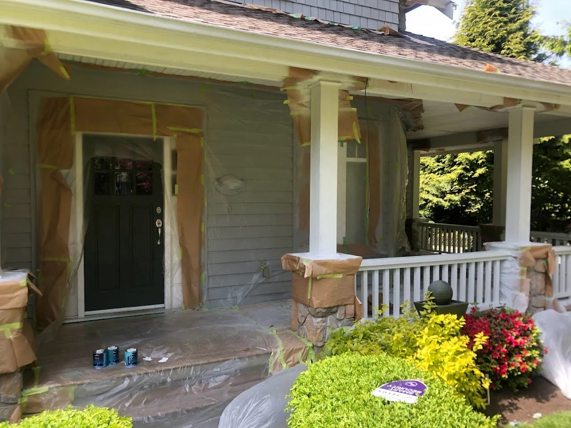 After spraying the siding, the posts and the railings / spindles. Next up: removing masking, painting the front door and staining (solid hide stain) the deck!