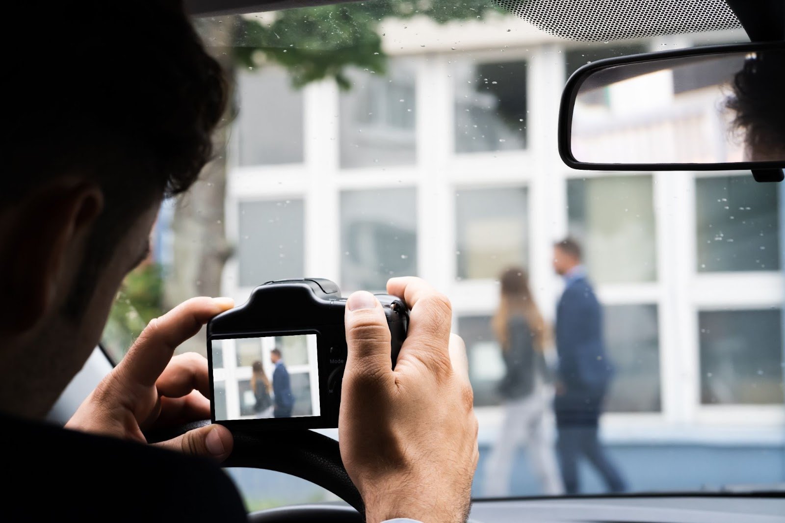 Private investigator conducting discreet surveillance and documenting activity from a vehicle