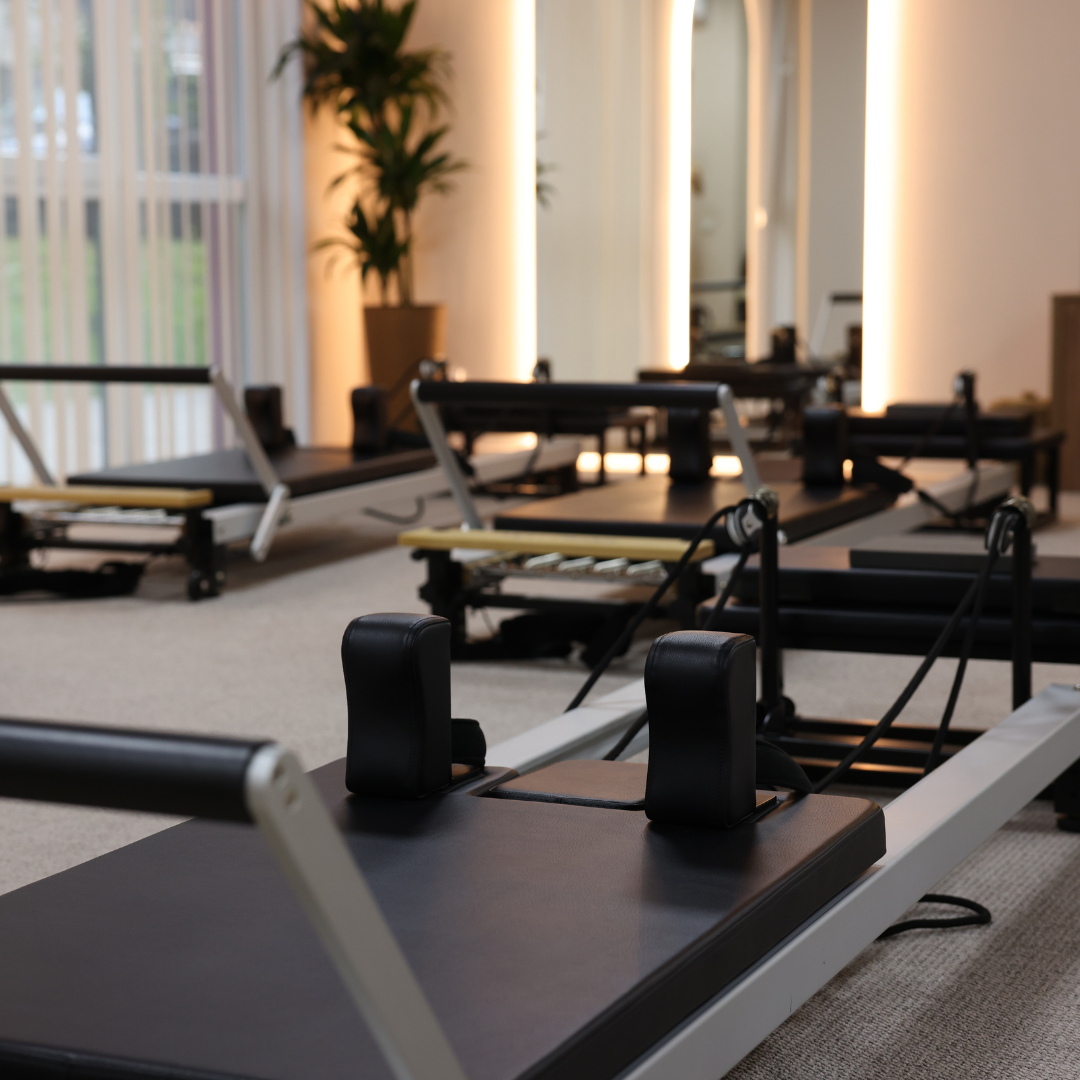 Row of pilates reformer machines in a fitness studio