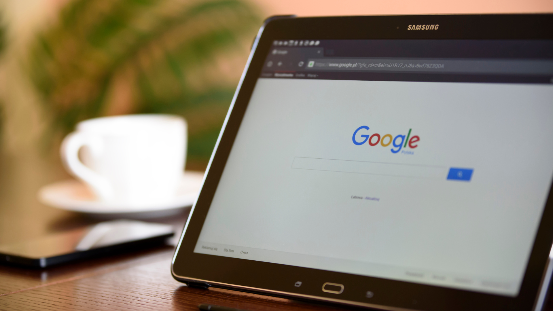 Tablet showing a Google search results page beside a cup of coffee