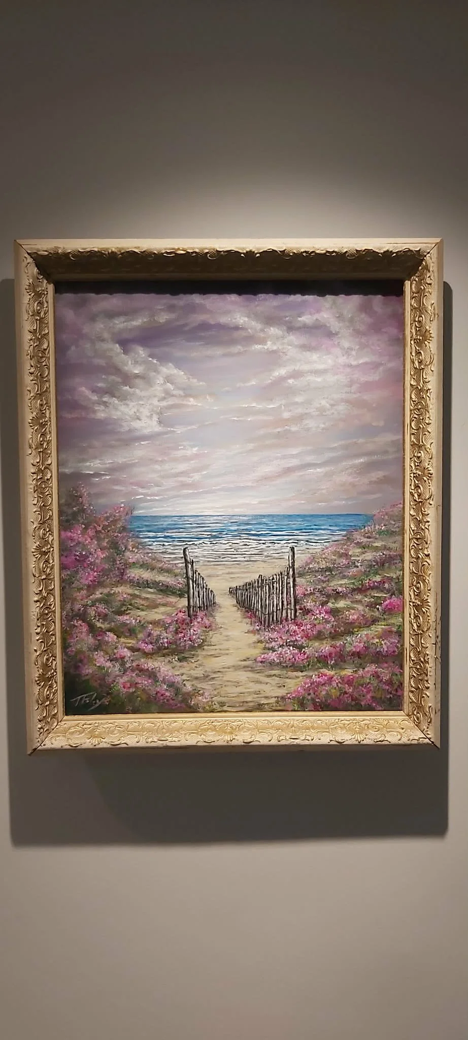 Painting of a sandy pathway leading to the ocean, lined with pink flowering bushes and a rustic gate, under a cloudy sky.