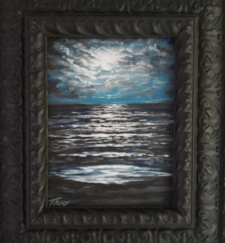A framed painting of a seascape with clouds, water, and reflections, signed in the bottom left corner.