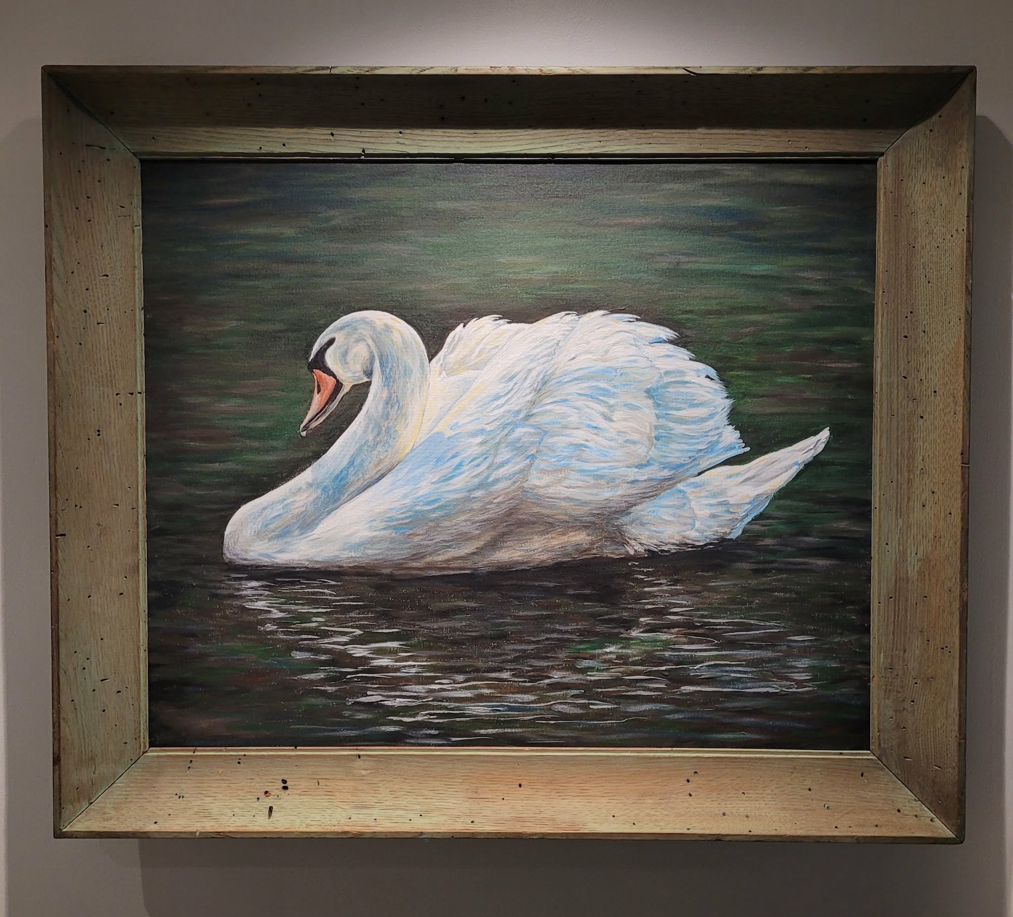 Painting of a swan on water, framed in a wooden shadow box.