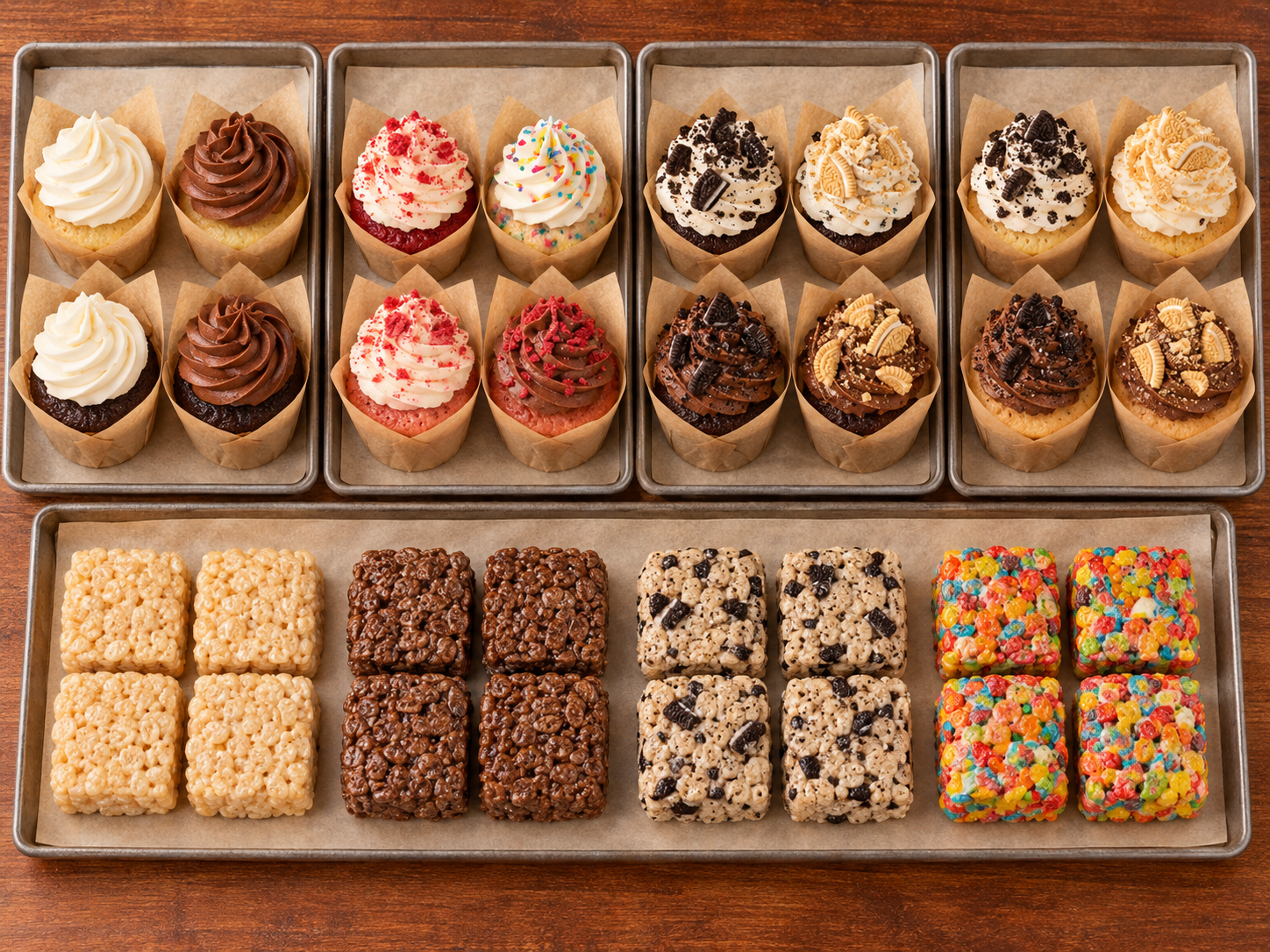 Tray of assorted cupcakes with various frosting and toppings in paper liners, and rice crispy treats in different flavors and colors on a wooden surface.
