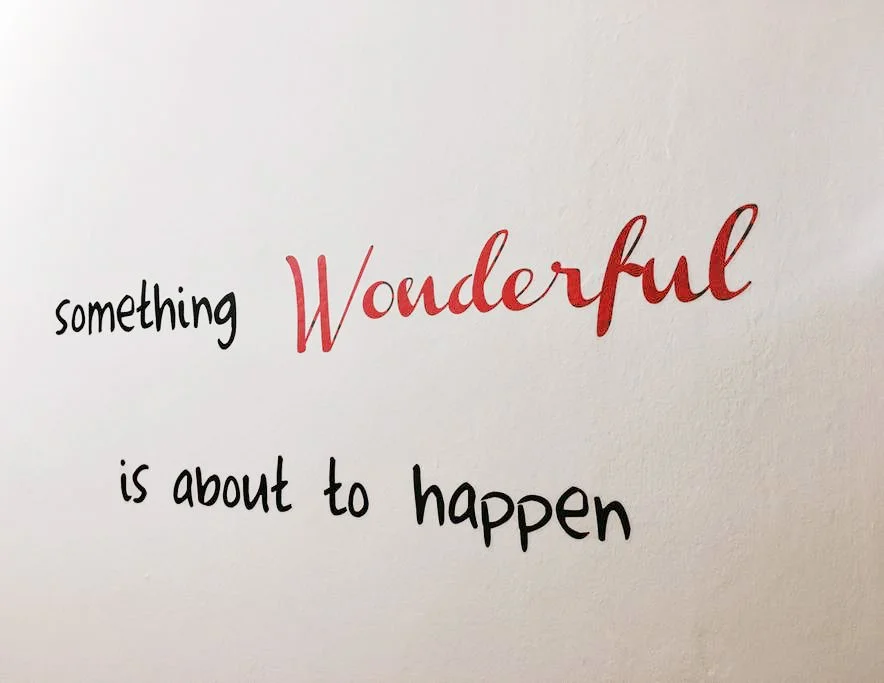 Decorative wall quote "something wonderful is about to happen" in the bedroom at Casa Luce Tuscany, a holiday apartment in Poggibonsi near Siena Eye Laser and San Gimignano.