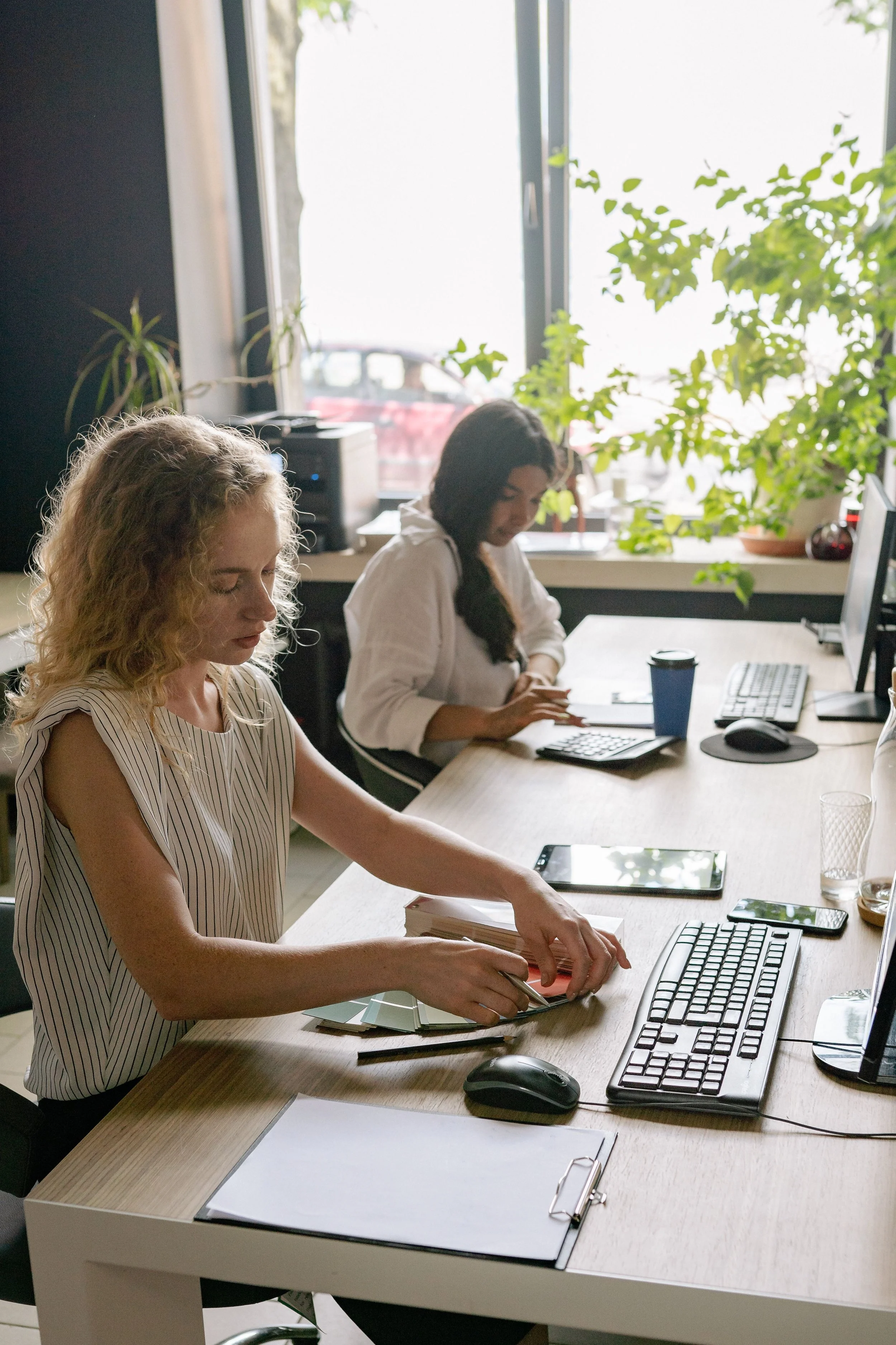 Two women working at a clean desk