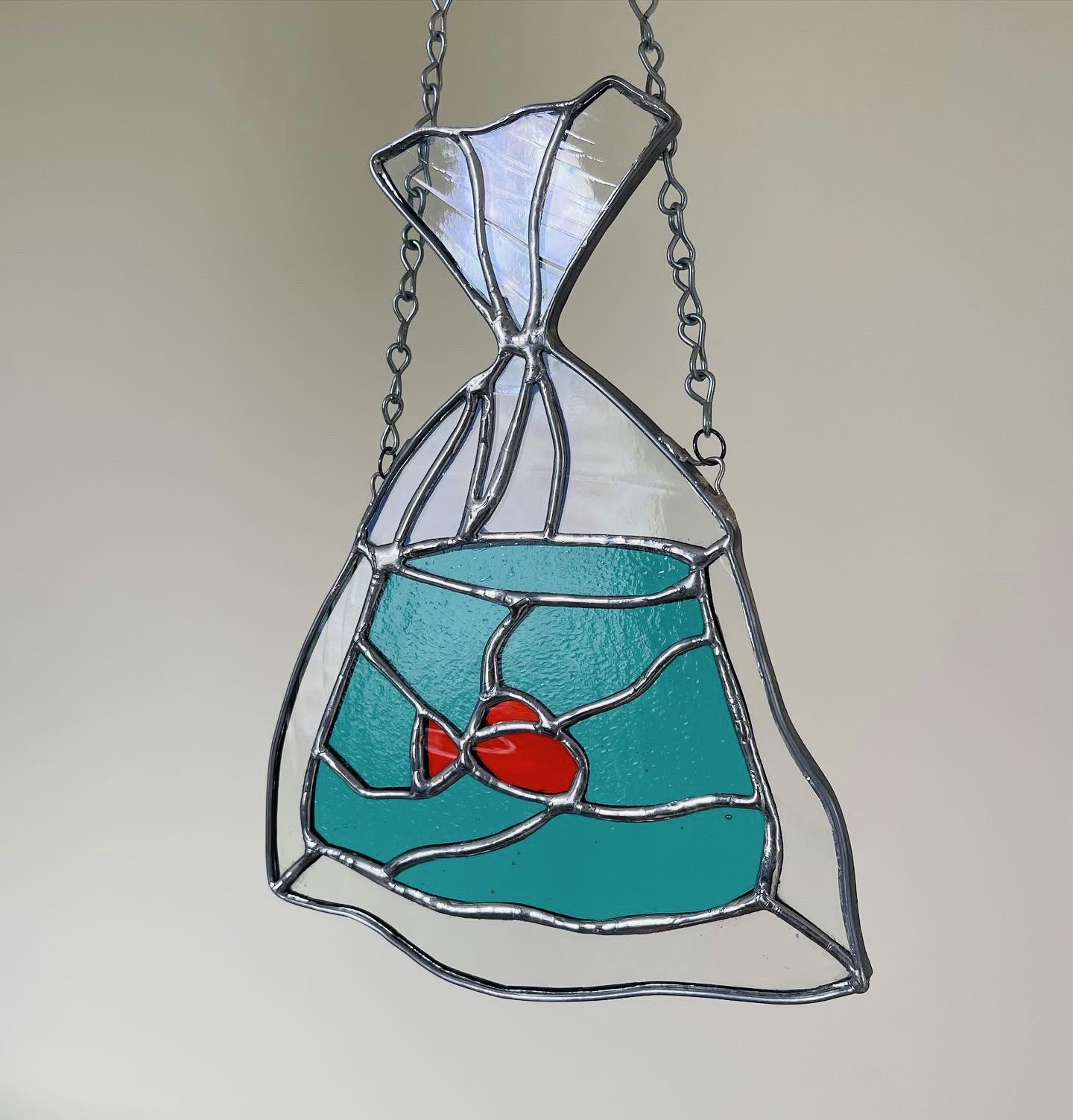Stained glass ornament depicting a goldfish in a bag, typical of one's you would win at a carnival or fair. 