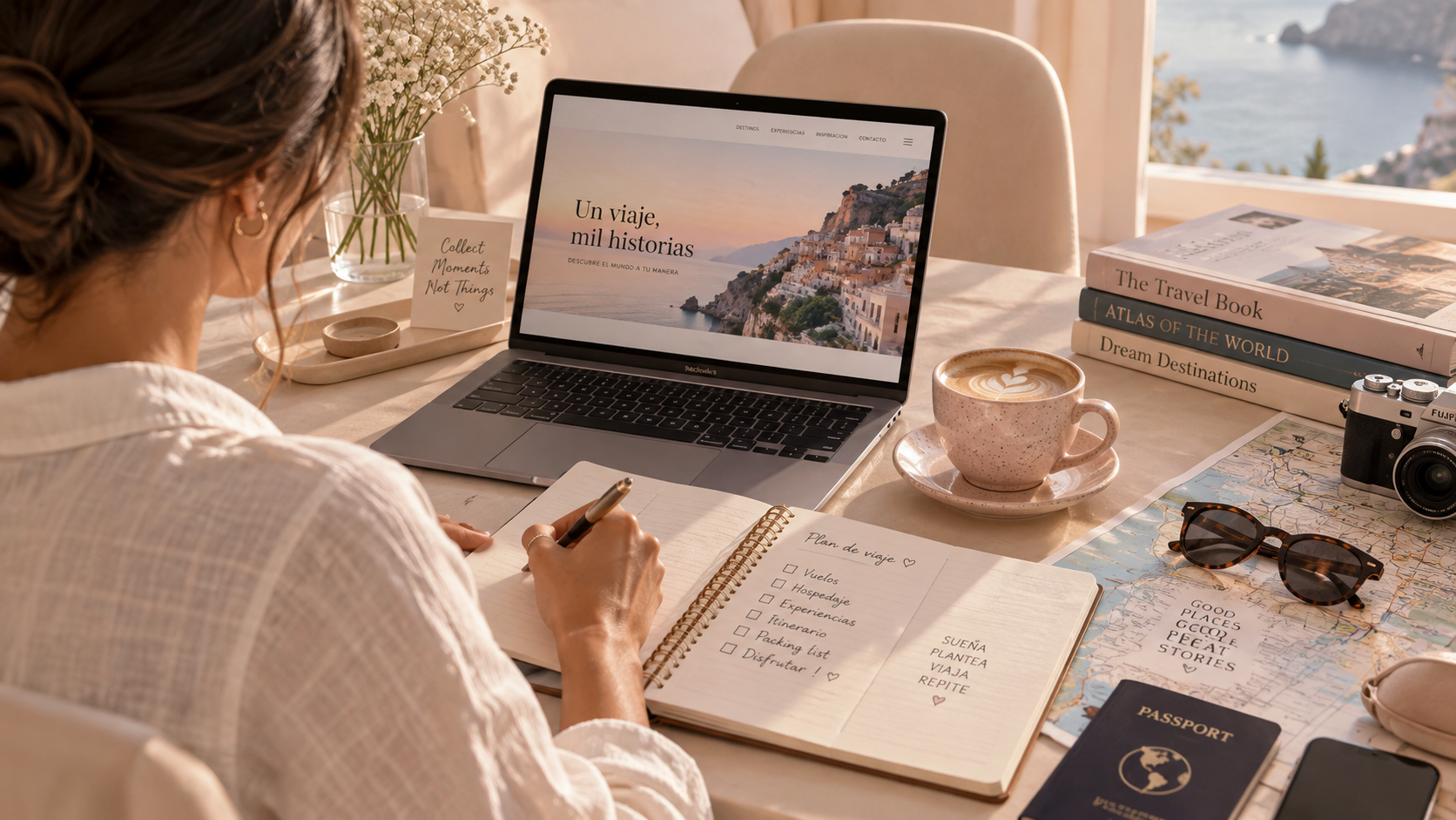 Mesa de trabajo con una laptop que muestra un sitio de viajes, una taza de café, varios libros sobre destinos turísticos, una cámara, gafas de sol, un mapamundi, un pasaporte, y una persona tomando notas en un cuaderno de planificación de viajes.