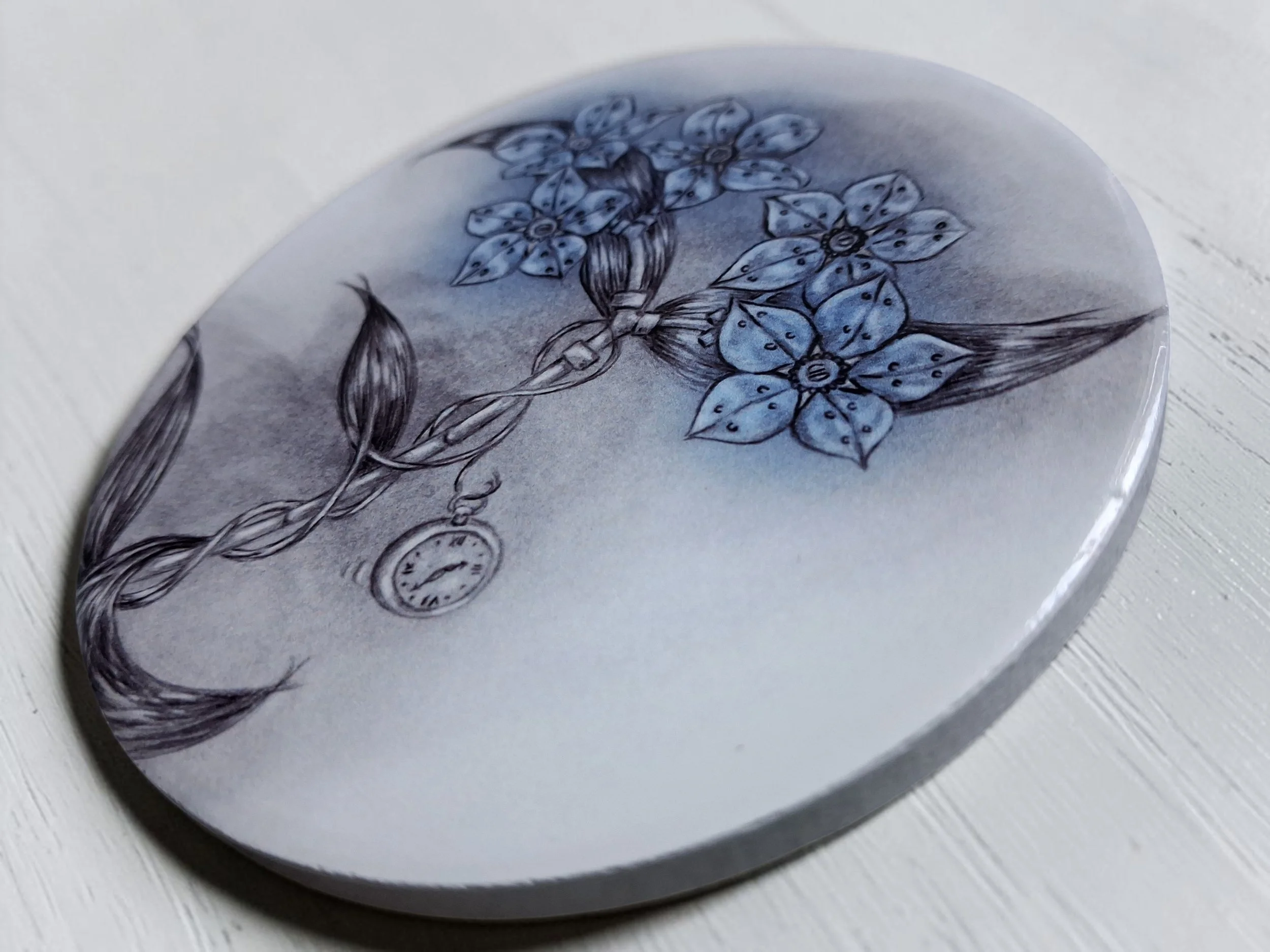 round glossy ceramic coaster flat lay, hand drawn artwork printed onto it featuring forget me not flower drawn in a steampunk style, with blue petals
