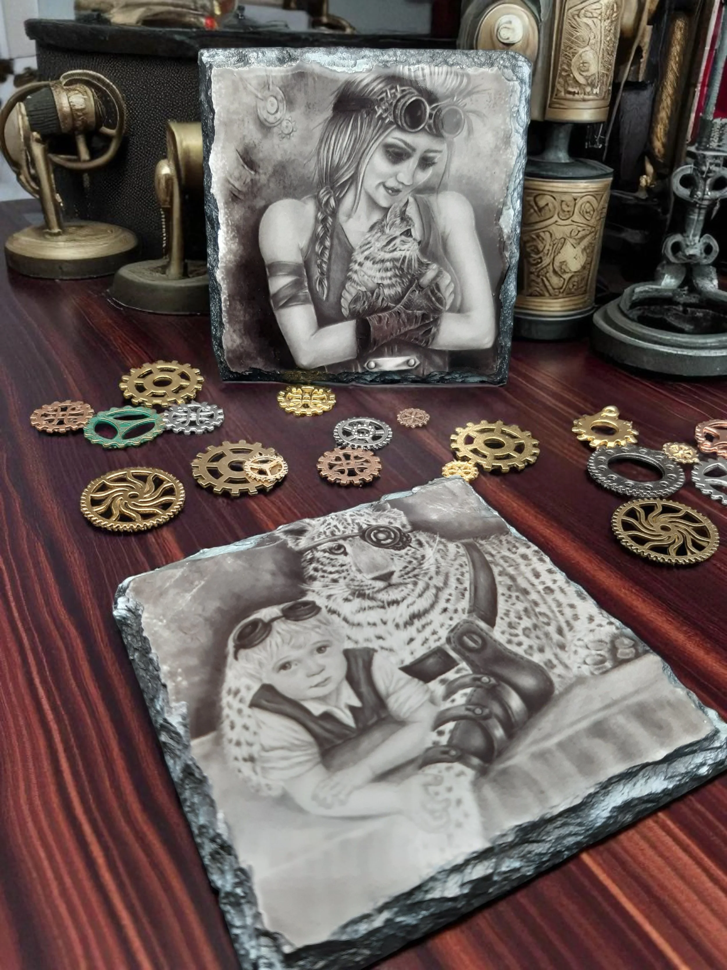 2 slates coasters with hand drawn steampunk artworks printed onto them with glossy finish, placed on wood table top with steampunk cogs scattered