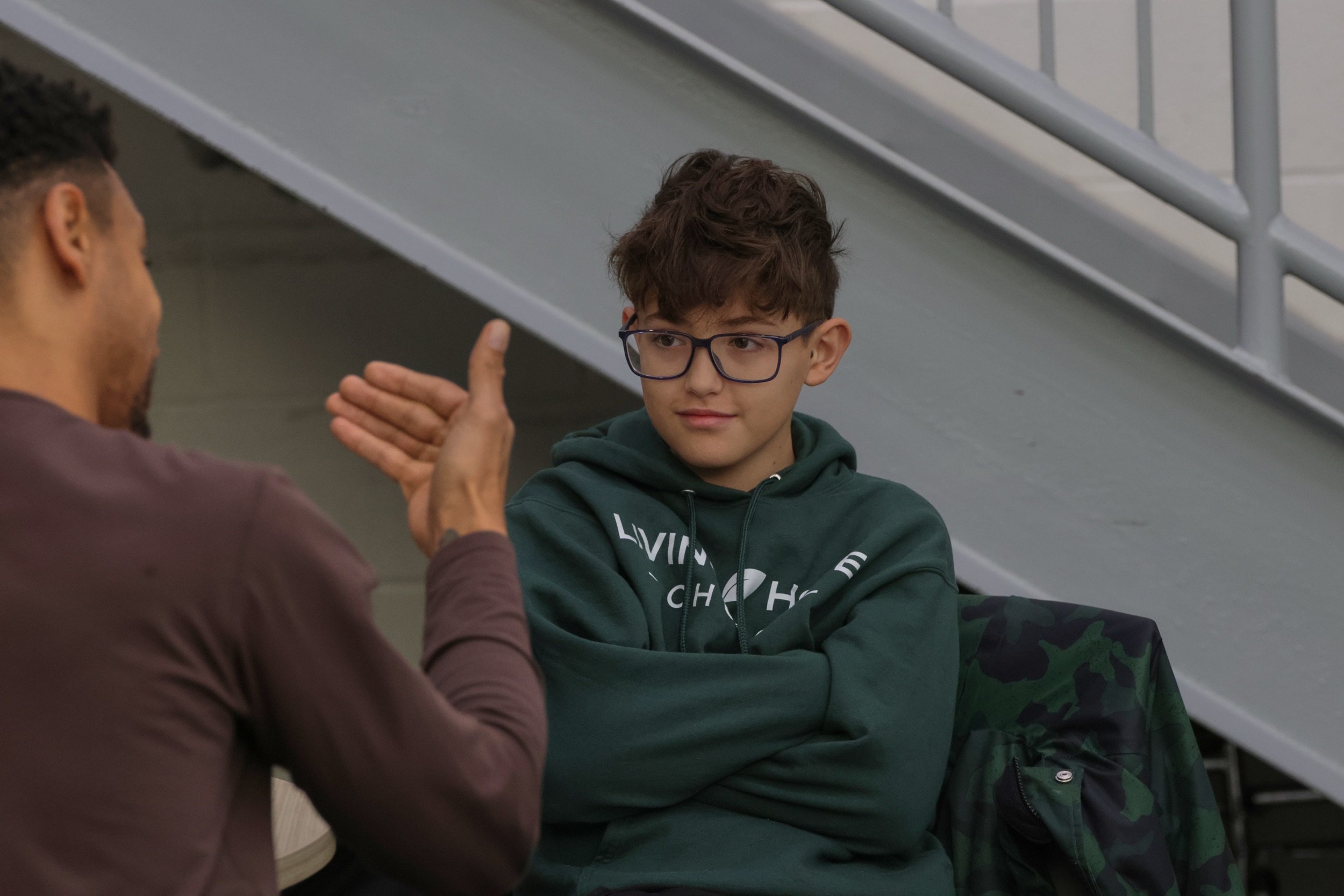 A Living Hope leader shares a high five with a student wearing a Living Hope Church hoodie.