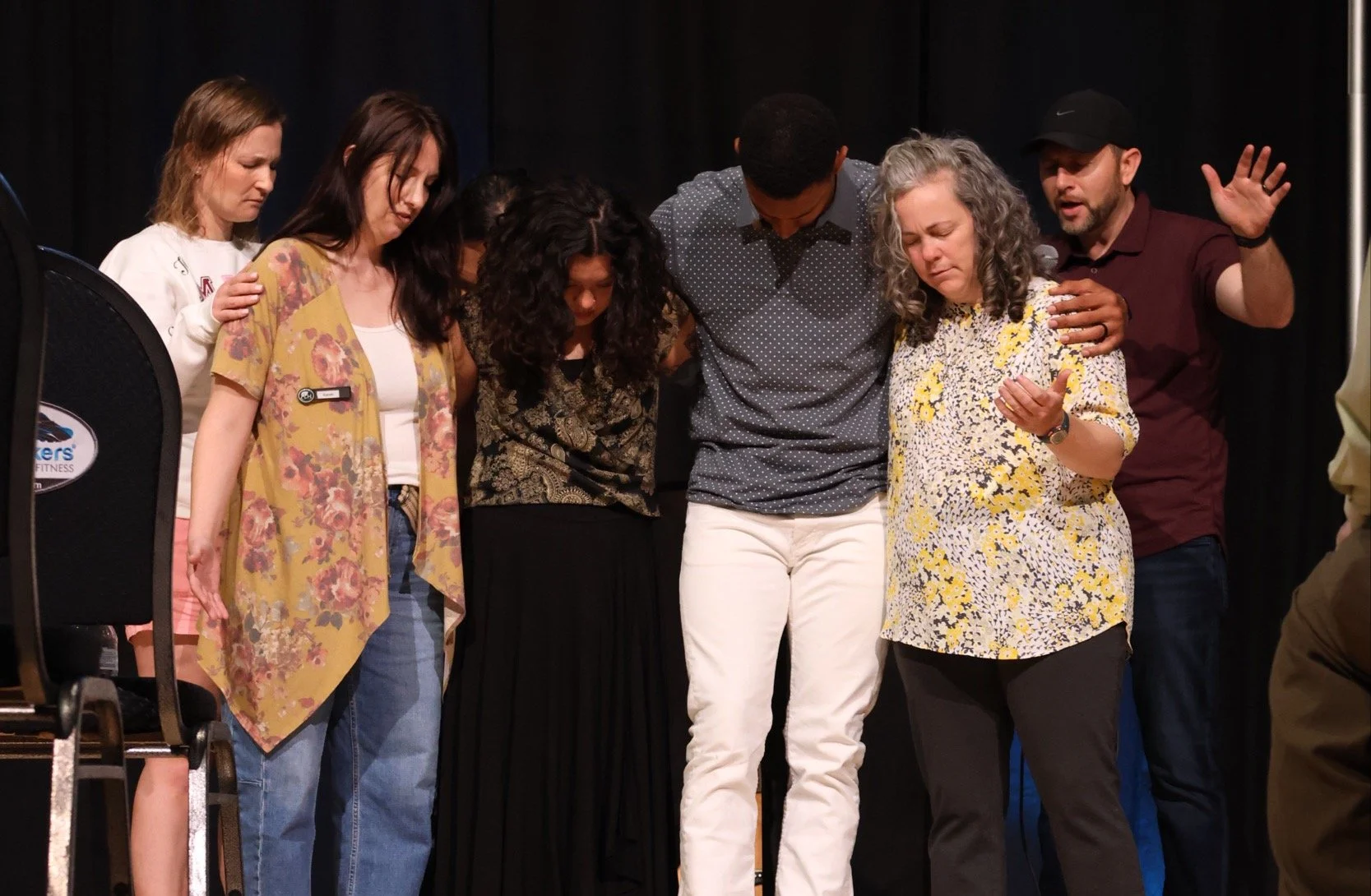 Members of Living Hope Church gather around and pray together at the front of a Sunday gathering.