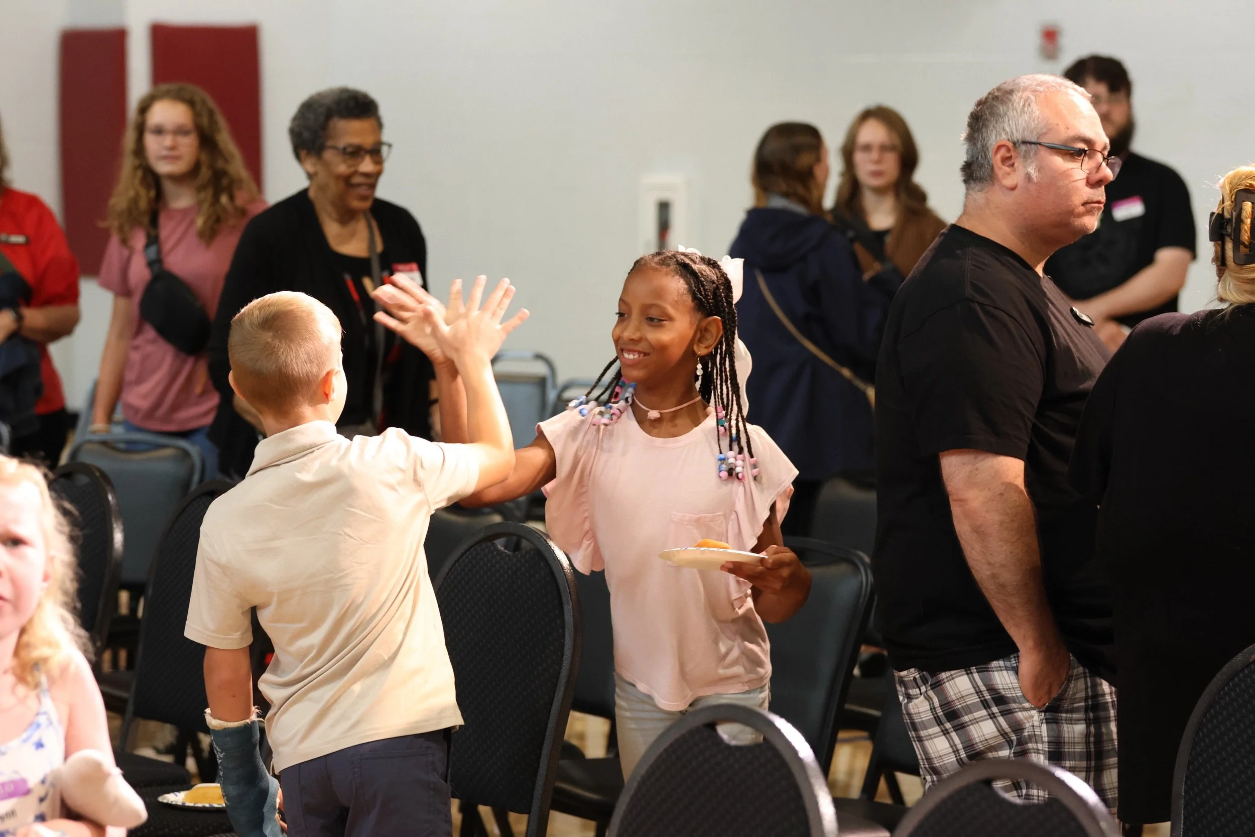 Two kids share a high five as families gather at Living Hope Church.