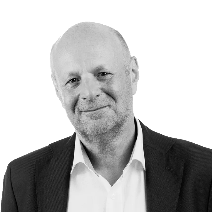 Black and white portrait of a mature man wearing a suit and white shirt, smiling gently against a plain background.