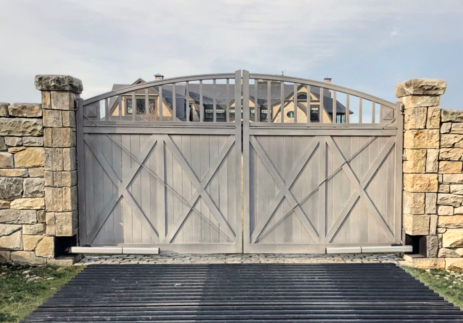 Automated driveway gate with stone pillars
