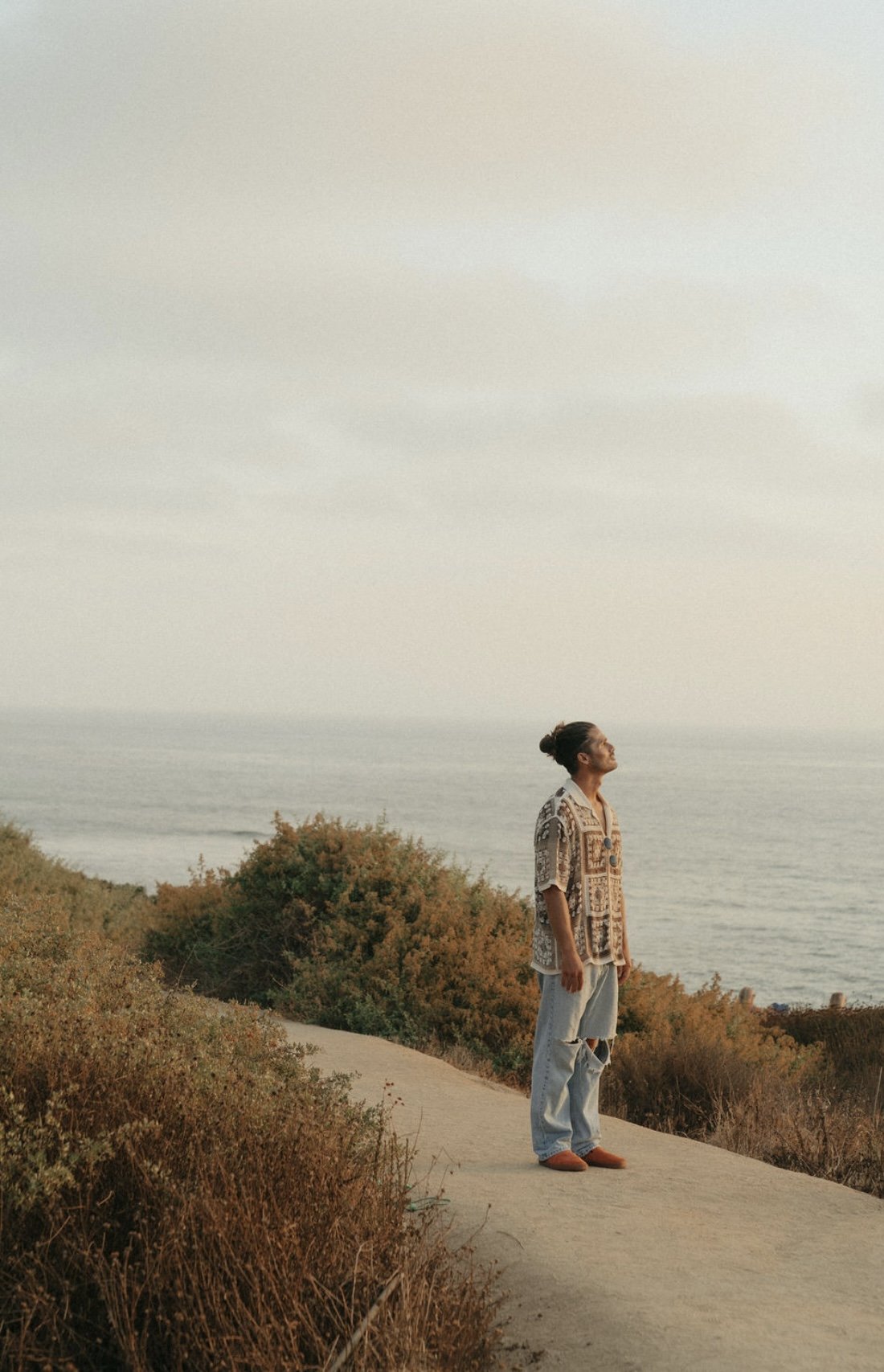 Taylor Garrison looking at the sky overlooking the ocean which is his happy place