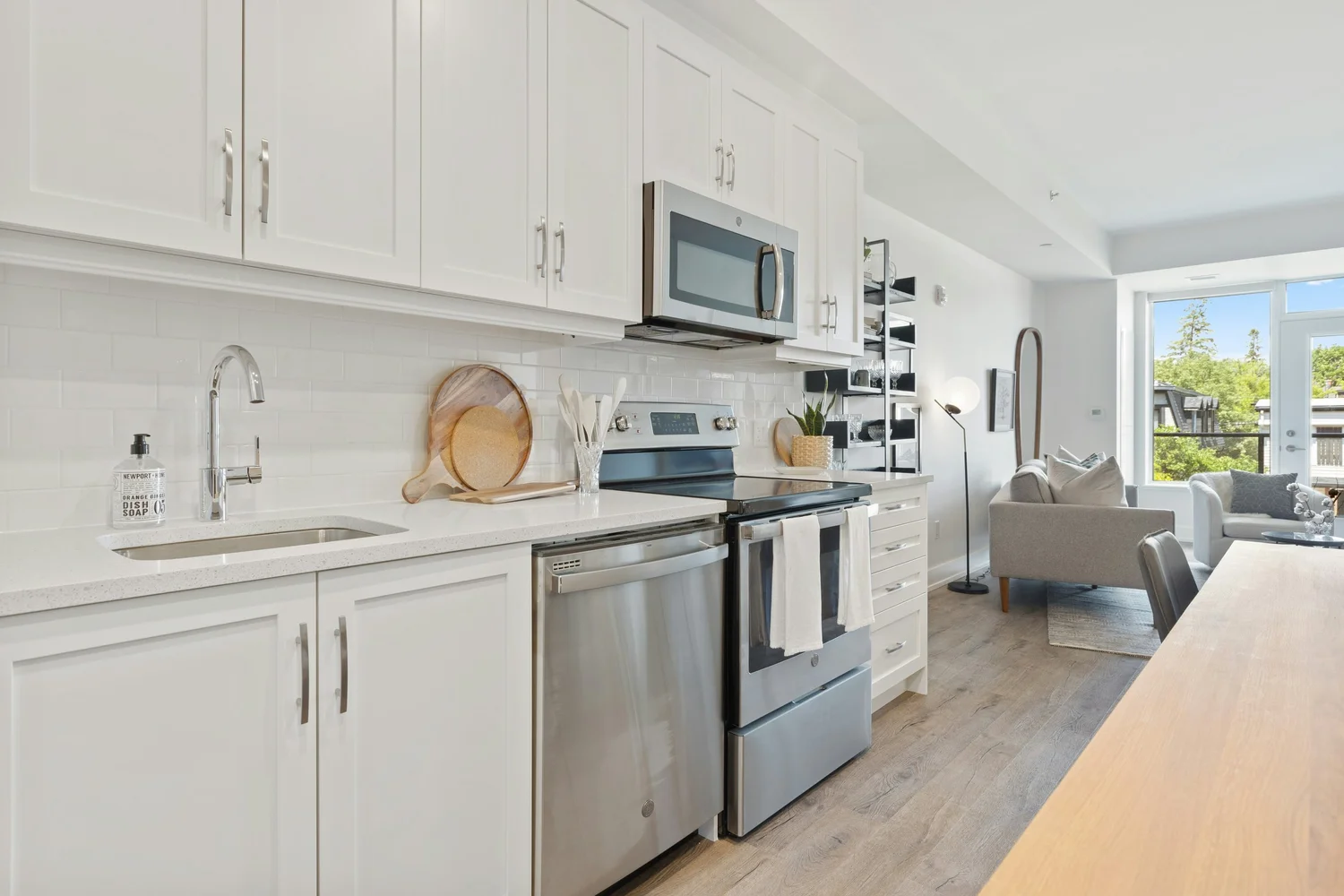 A bright apartment kitchen opening onto the living room