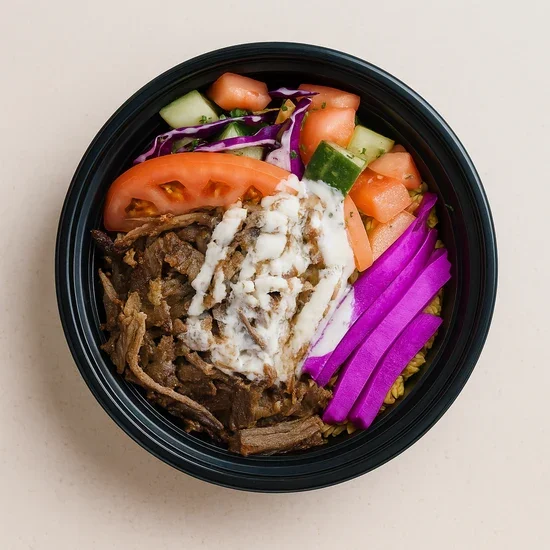 Mixed salad in a black bowl with tomatoes, cucumbers, purple radish, shredded beef, and shredded cheese.