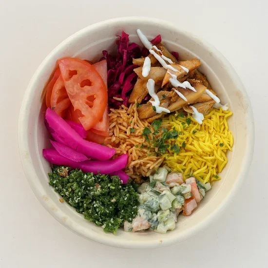 A bowl of Indian food with tomato, pickled onions, rice, curry, salad, and garnishes.