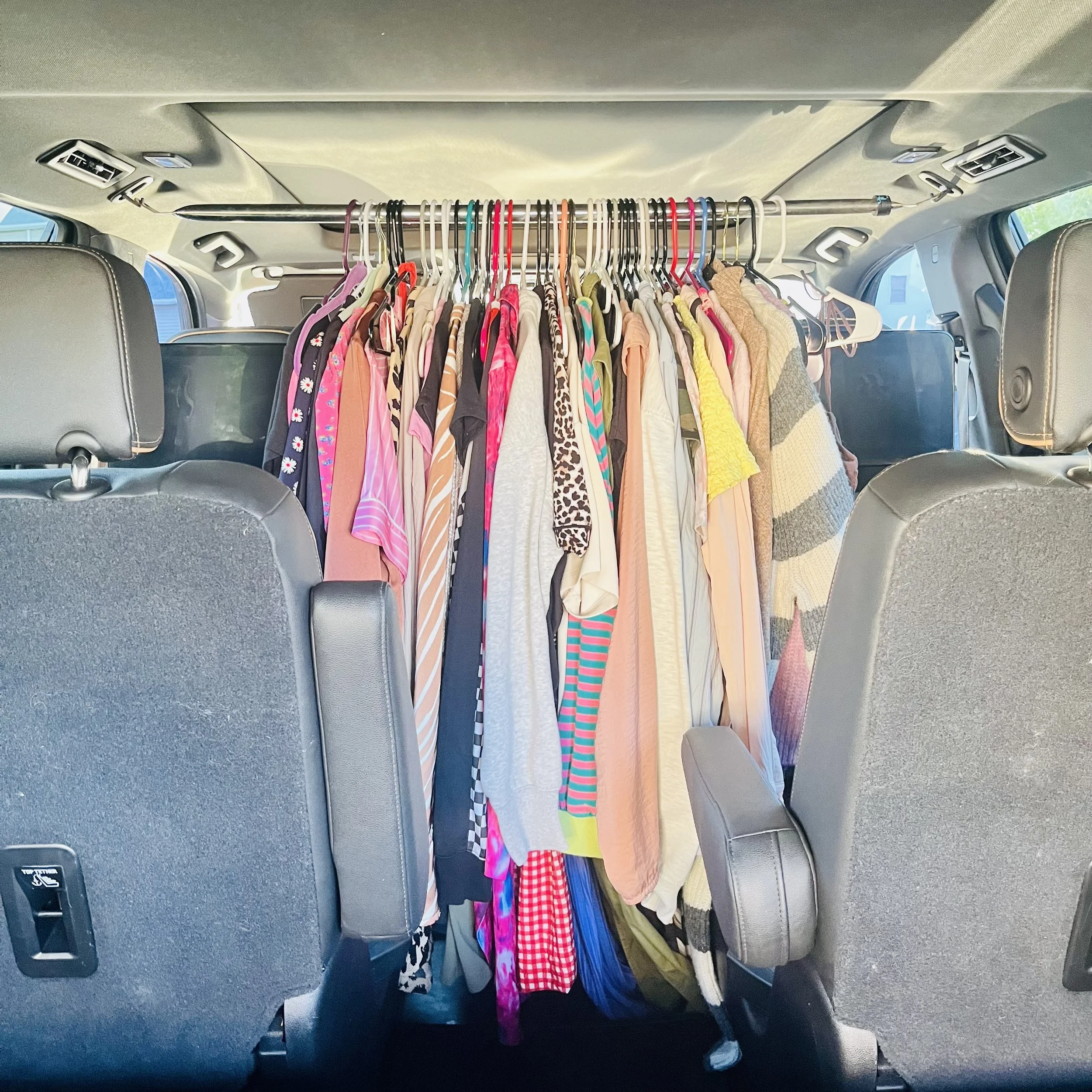 Clean clothes hanging neatly in a vehicle, ready for laundry delivery.