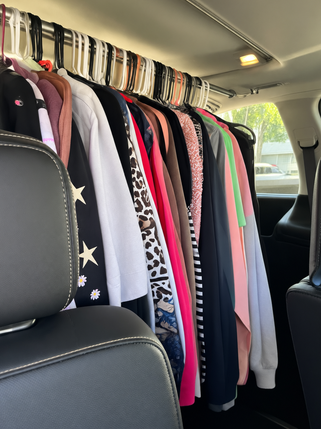 Clean clothes hanging neatly in a vehicle, ready for delivery to a customer.
