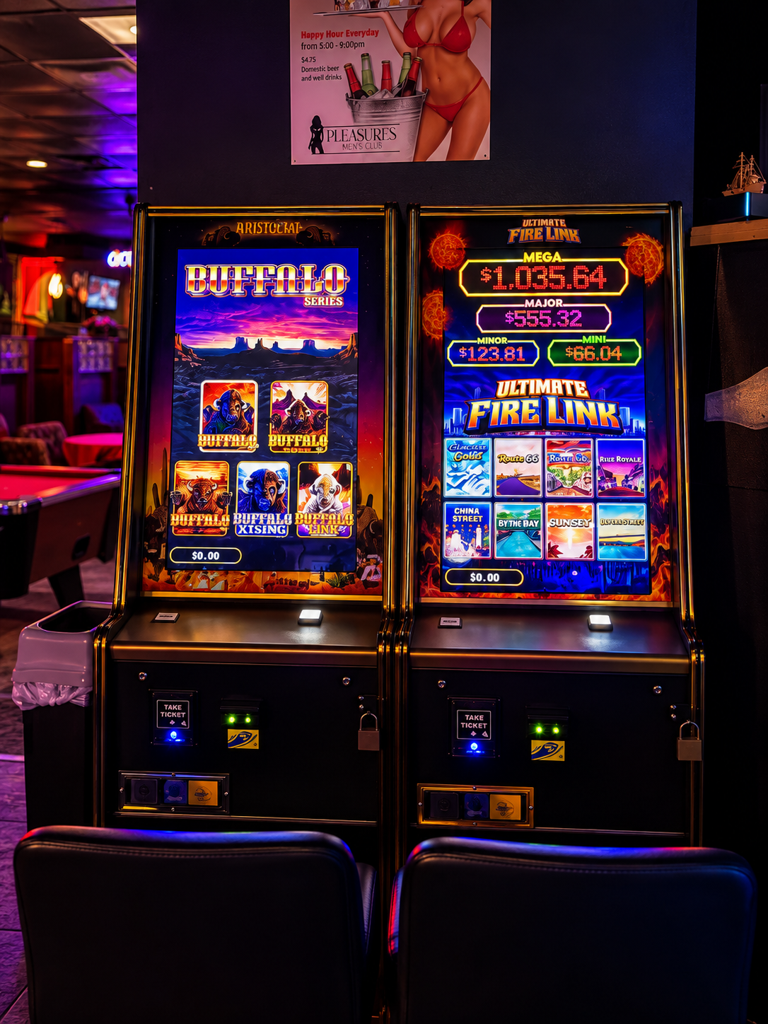 Two illuminated slot machines in a dimly lit bar or arcade, with colorful game graphics and payout amounts displayed on screens.