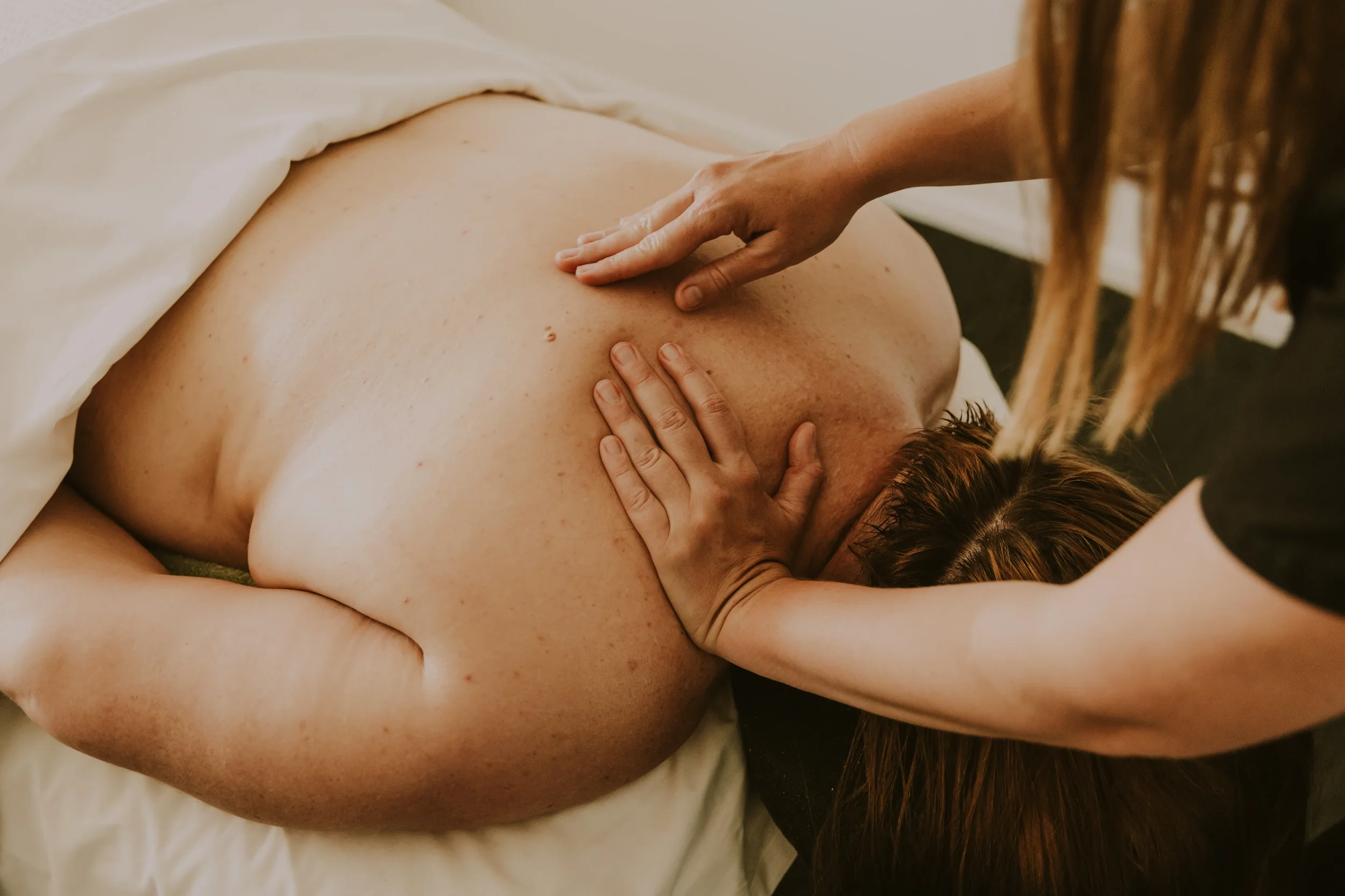 Person receiving a massage on their back in a spa or massage setting.