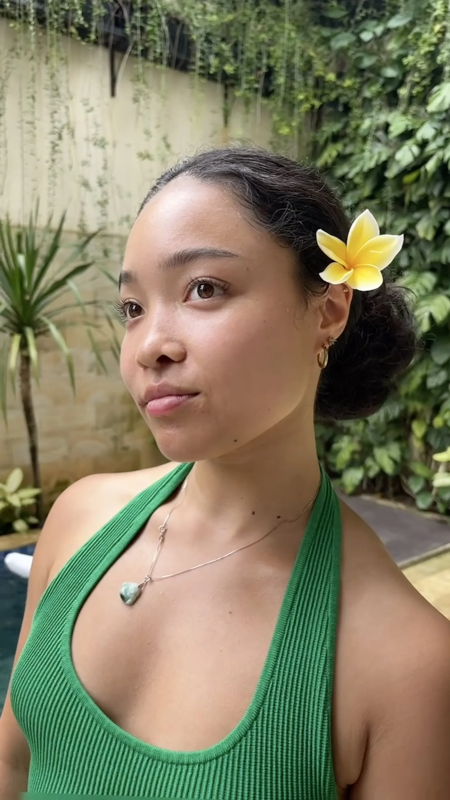 Katie Jones with a frangipani flower in her hair, in a green top