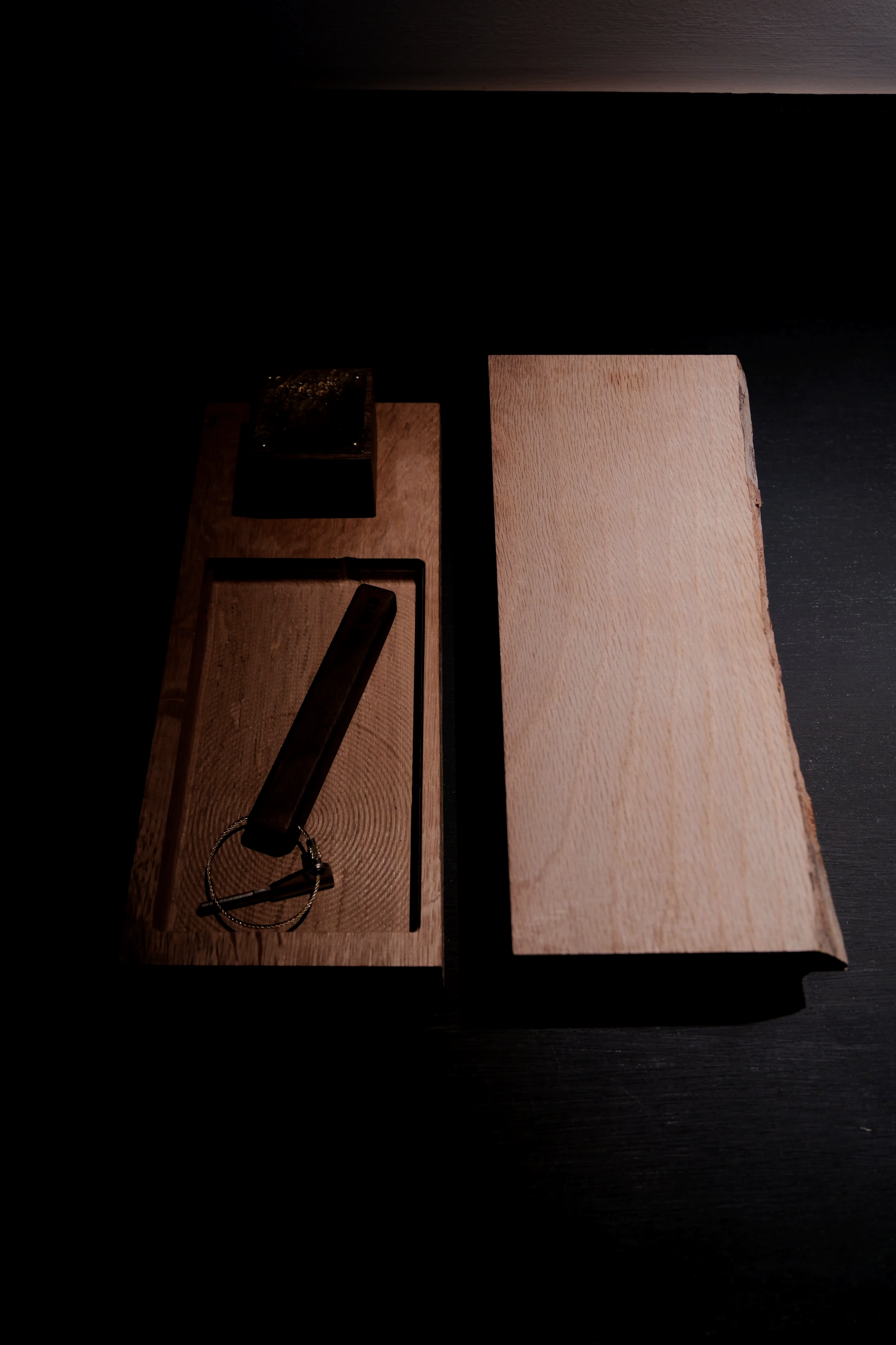 Close-up of a wooden table with a dark-colored box and a keychain with a leather strap, in a Japanese ryokan room entrance.