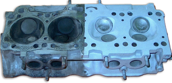 Comparison of a dirty, used engine cylinder head on the left and a clean, refurbished cylinder head on the right.