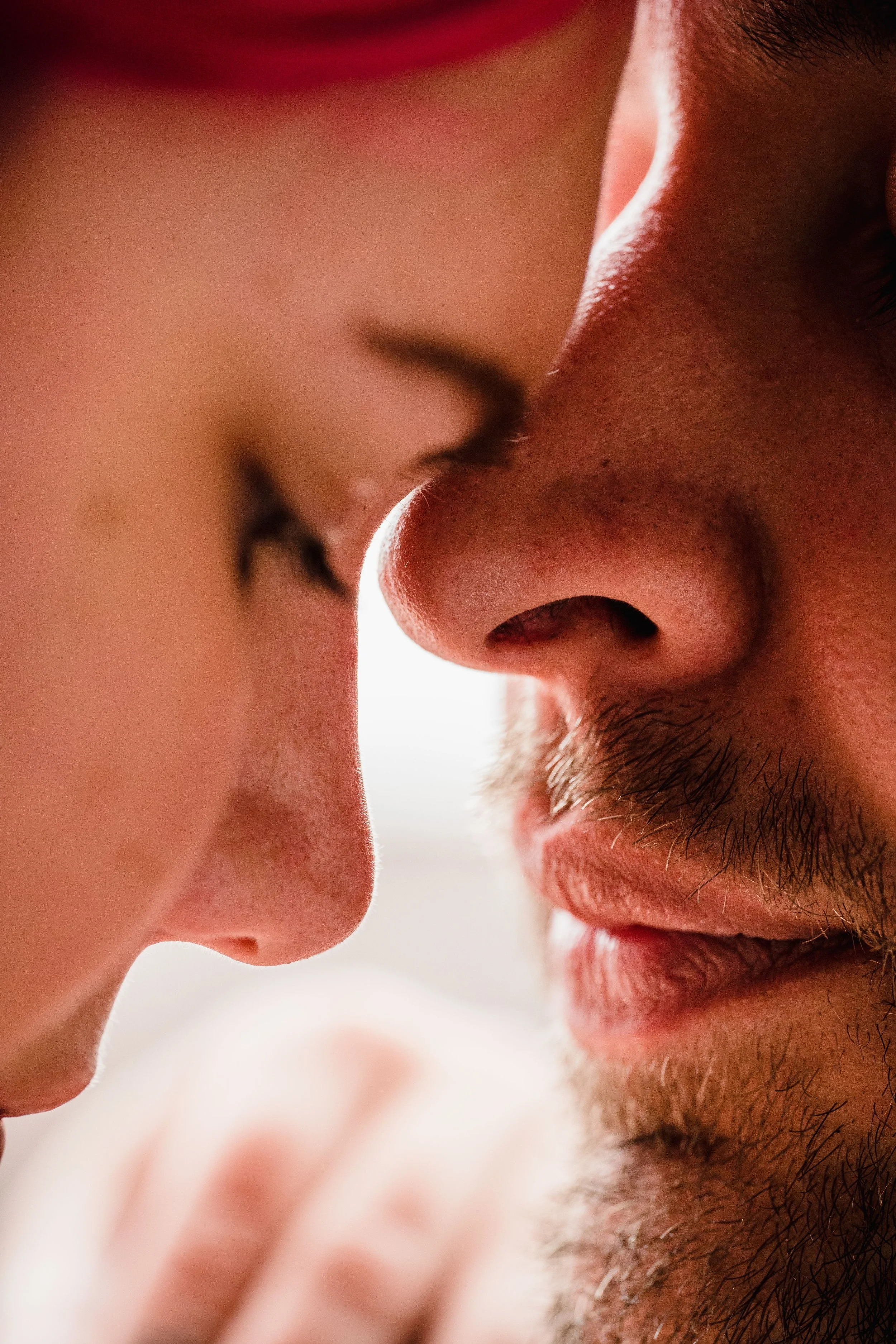 Close-up of a man and woman about to kiss, showing their faces and noses close together.