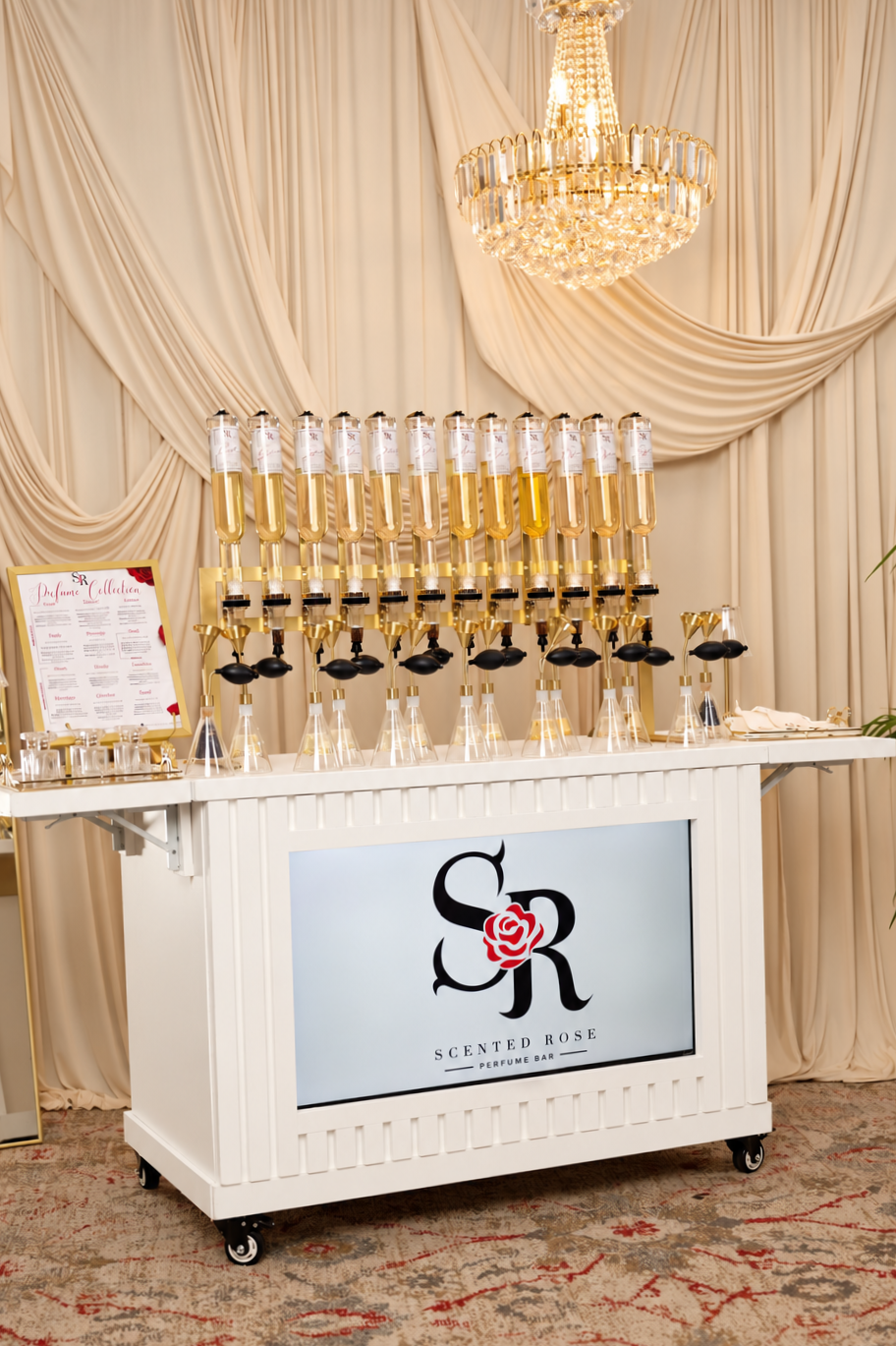 Scented Rose perfume bar cart with fragrance bottles, crystal chandelier, and draped cream backdrop