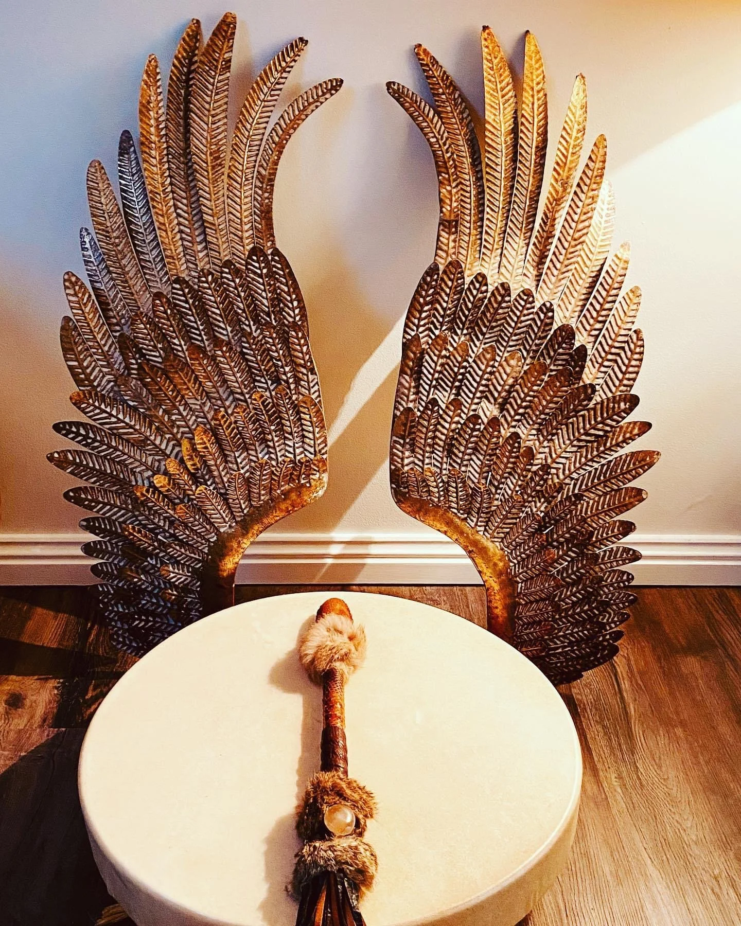 Decorative chair with ornate feathered backrest and a small animal resembling a bird on a white table.
