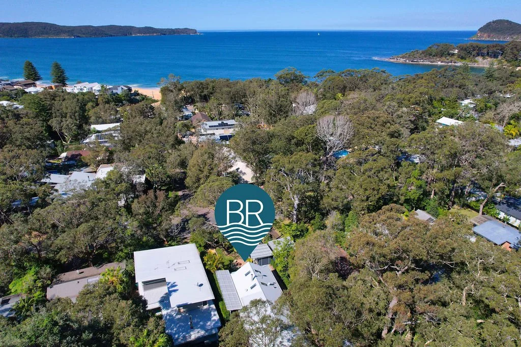 Yaraana Pearl beach holiday Luxury house Diamond road Aerial view of a coastal area with houses surrounded by trees, leading to a beach and ocean in the background, under a clear blue sky.