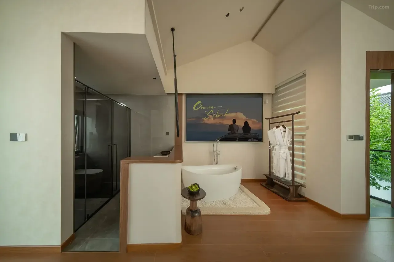 Modern bathroom with a free-standing bathtub, a walk-in shower, and a robe on a wooden rack.