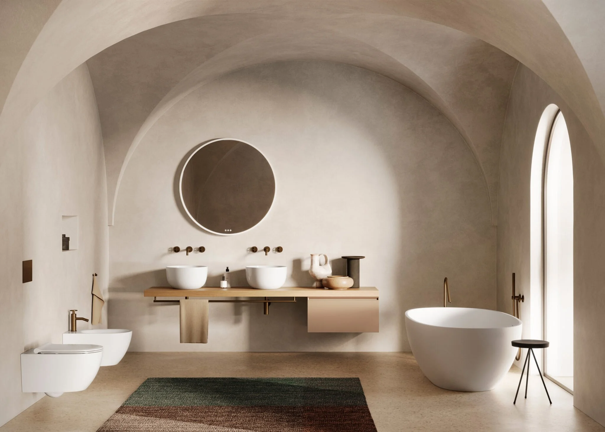 Minimalist bathroom with curved walls, a freestanding bathtub, wall-mounted sinks with brass faucets, a large circular mirror, and decorative pottery. Neutral color palette with natural light.