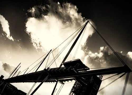 Low-angle photo of a ship's mast and rigging against a cloudy sky.
