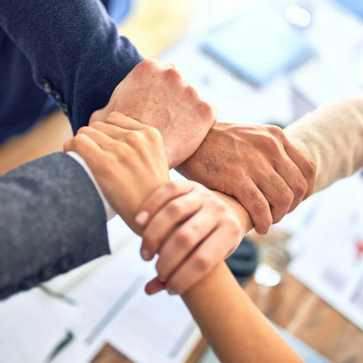 Groupe de personnes se tenant par la main en symbolisant l'unité et la collaboration.
