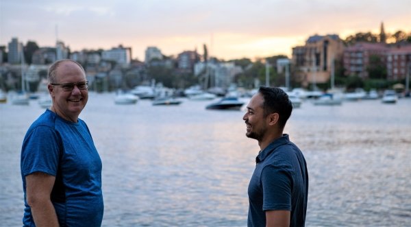 Personal trainer with an older adult client during an outdoor coaching session by the water.