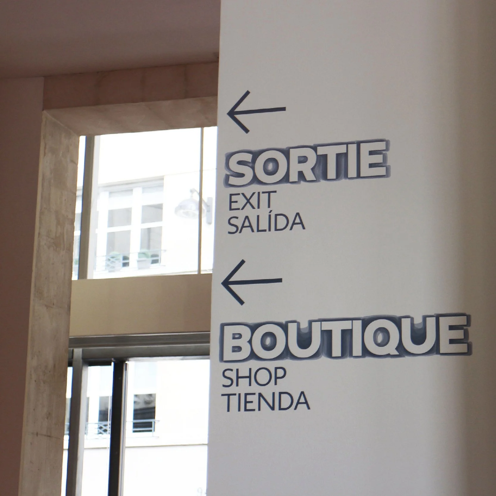 Signalétique d'orientation du Musée Rodin « Sortie » et « Boutique » avec flèches, textes en français, anglais et espagnol
