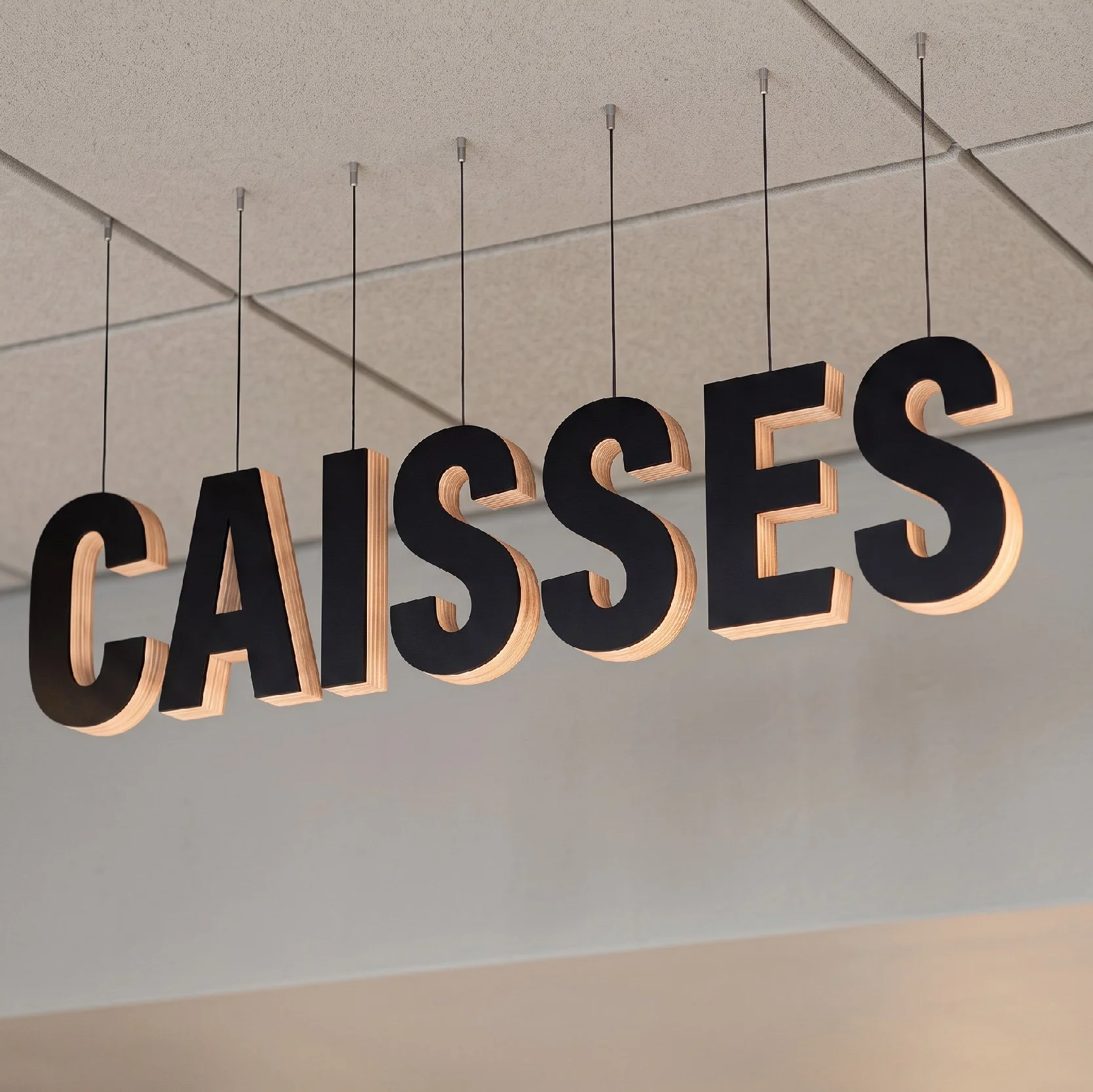 Lettrage « Caisses » en relief suspendu au plafond, signalétique pérenne Monoprix