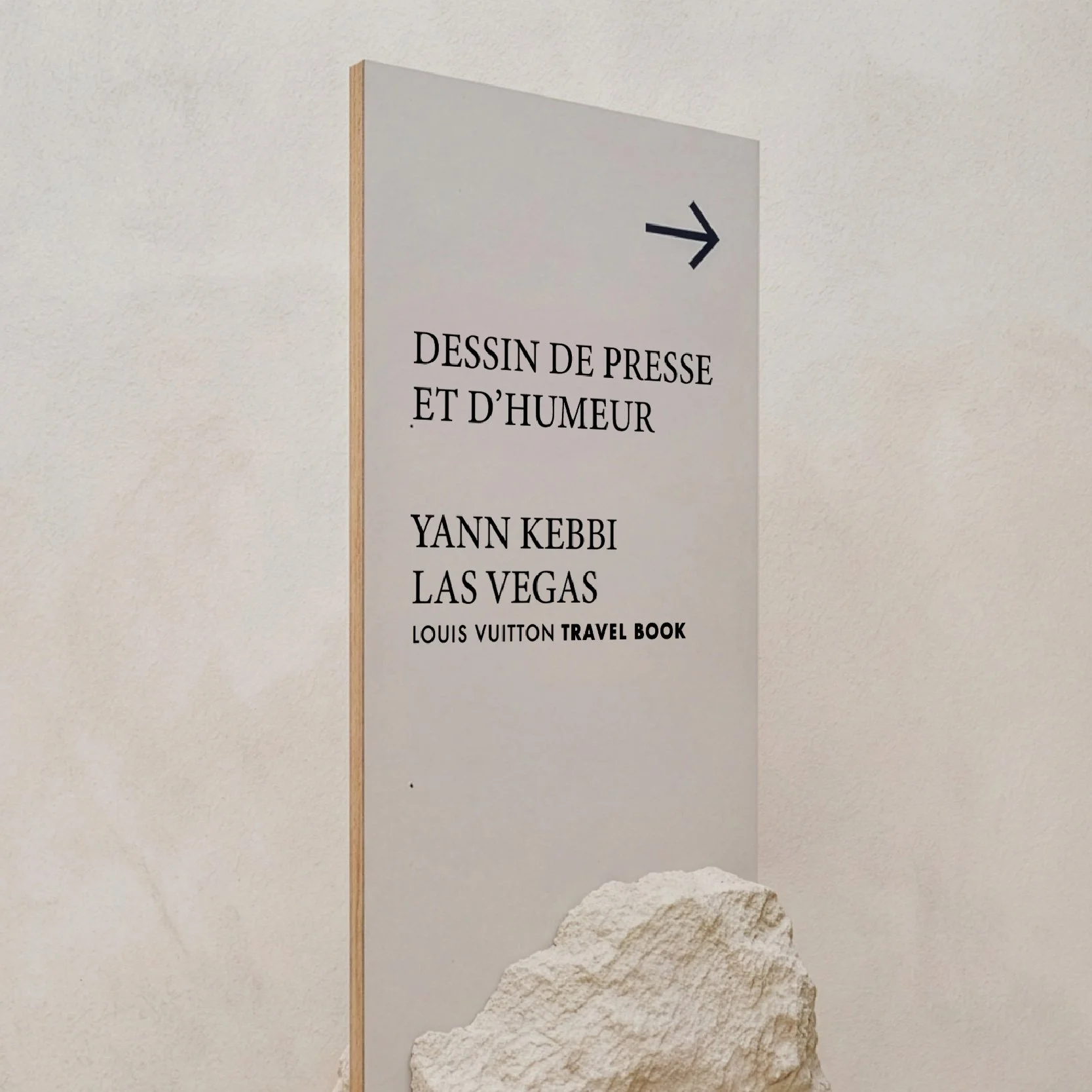 Signalétique du Festival du dessin sur socle de pierre brute, panneau d'orientation « Dessin de presse et d'humeur » avec flèche