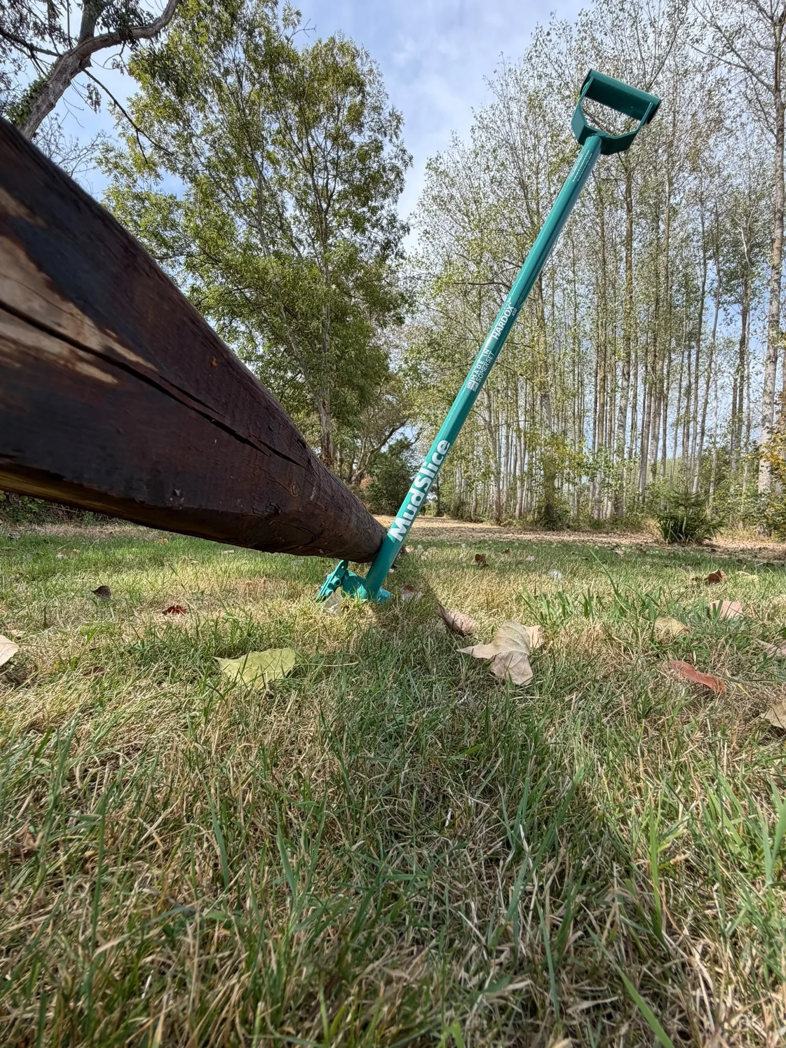 A turquoise MudSlice Earth Junkie Rage spade digging into the ground demonstrating new stay spike design feature.